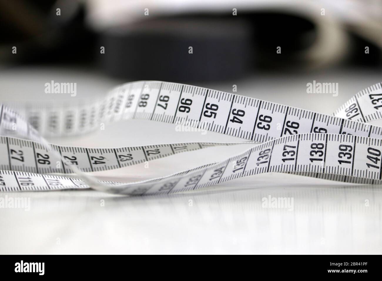 view of a tailor's tape measure on the workbench of a high fashion factory in italy Stock Photo
