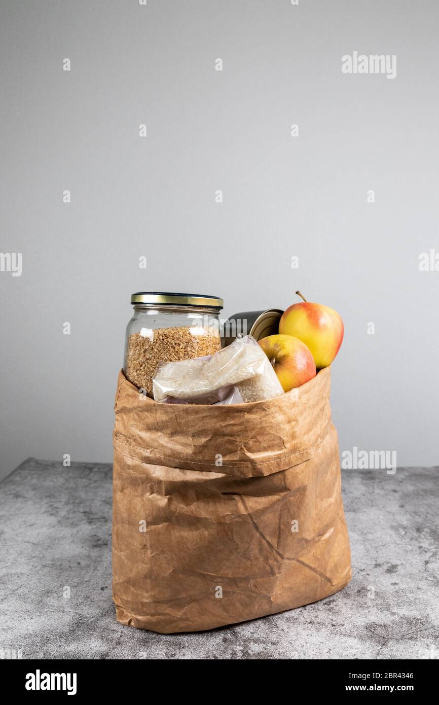Donation paper bag food supplies for people in isolation on a gray