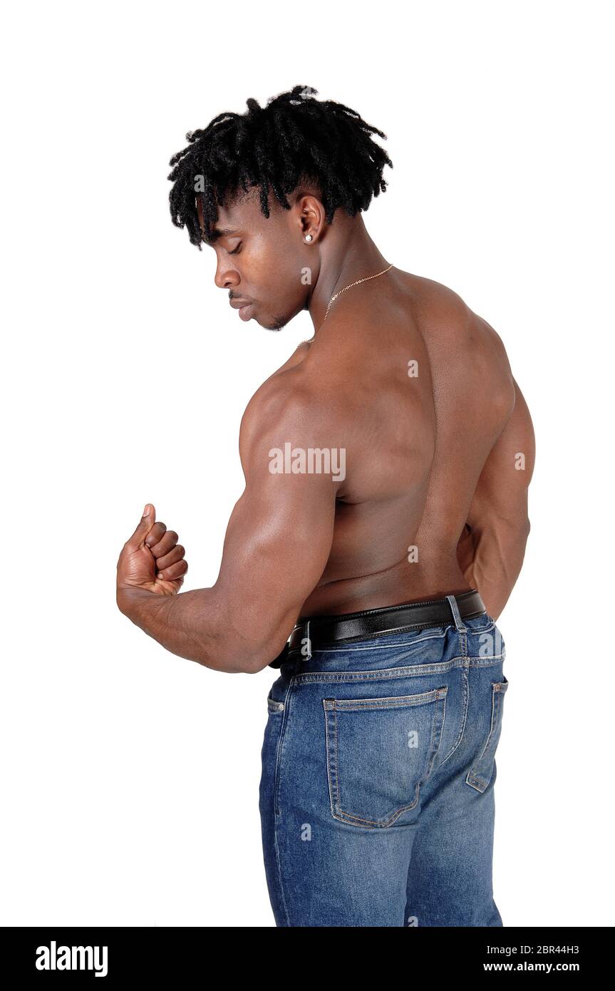 A young handsome bodybuilder standing from the back shirtless in jeans and  flexing , looking down, isolated for white background Stock Photo - Alamy