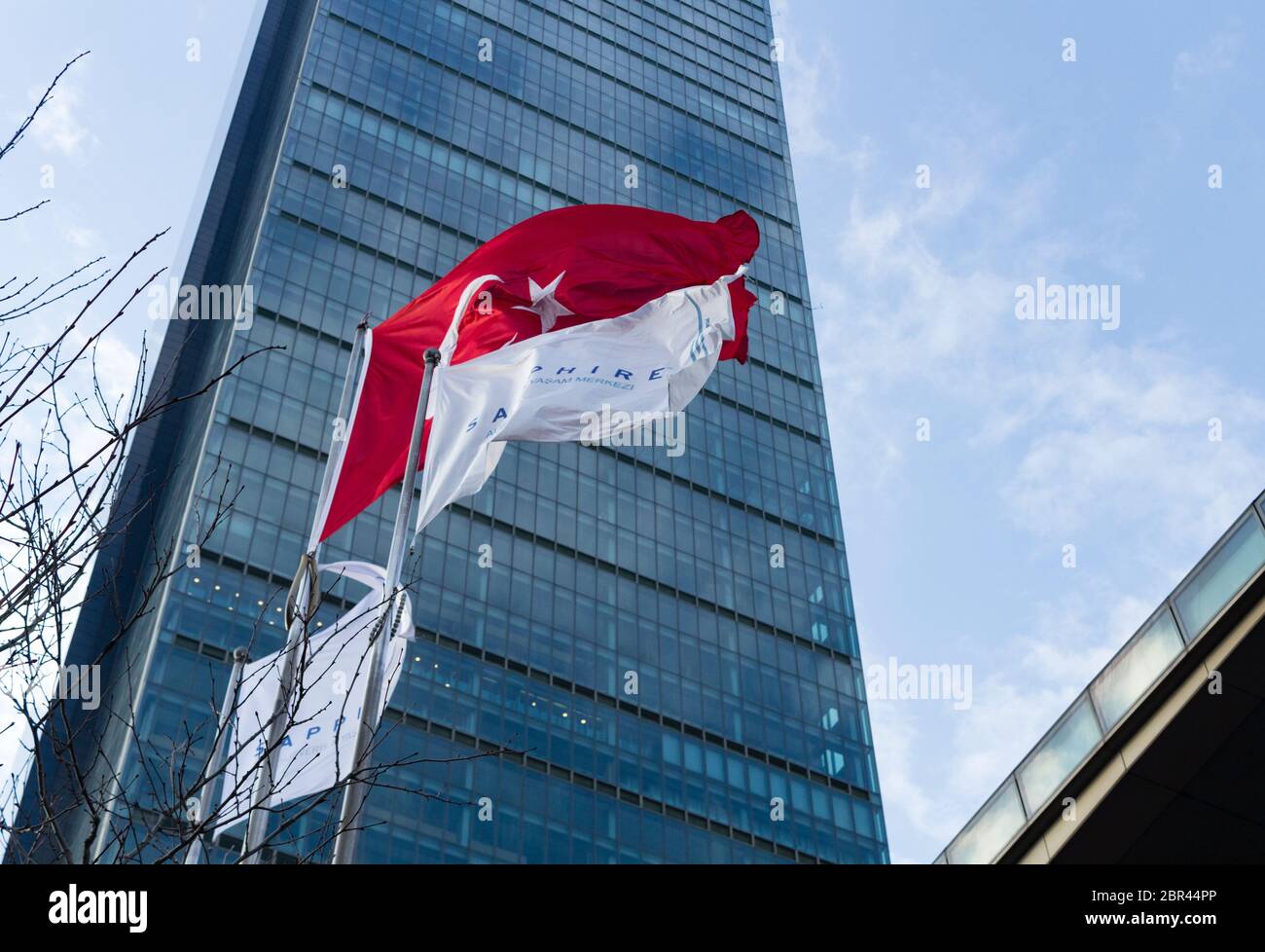Sapphire shopping mall and residential complex in narrow low angle view image with Turkish flag and company flags at Levent, Istanbul, Turkey. Stock Photo