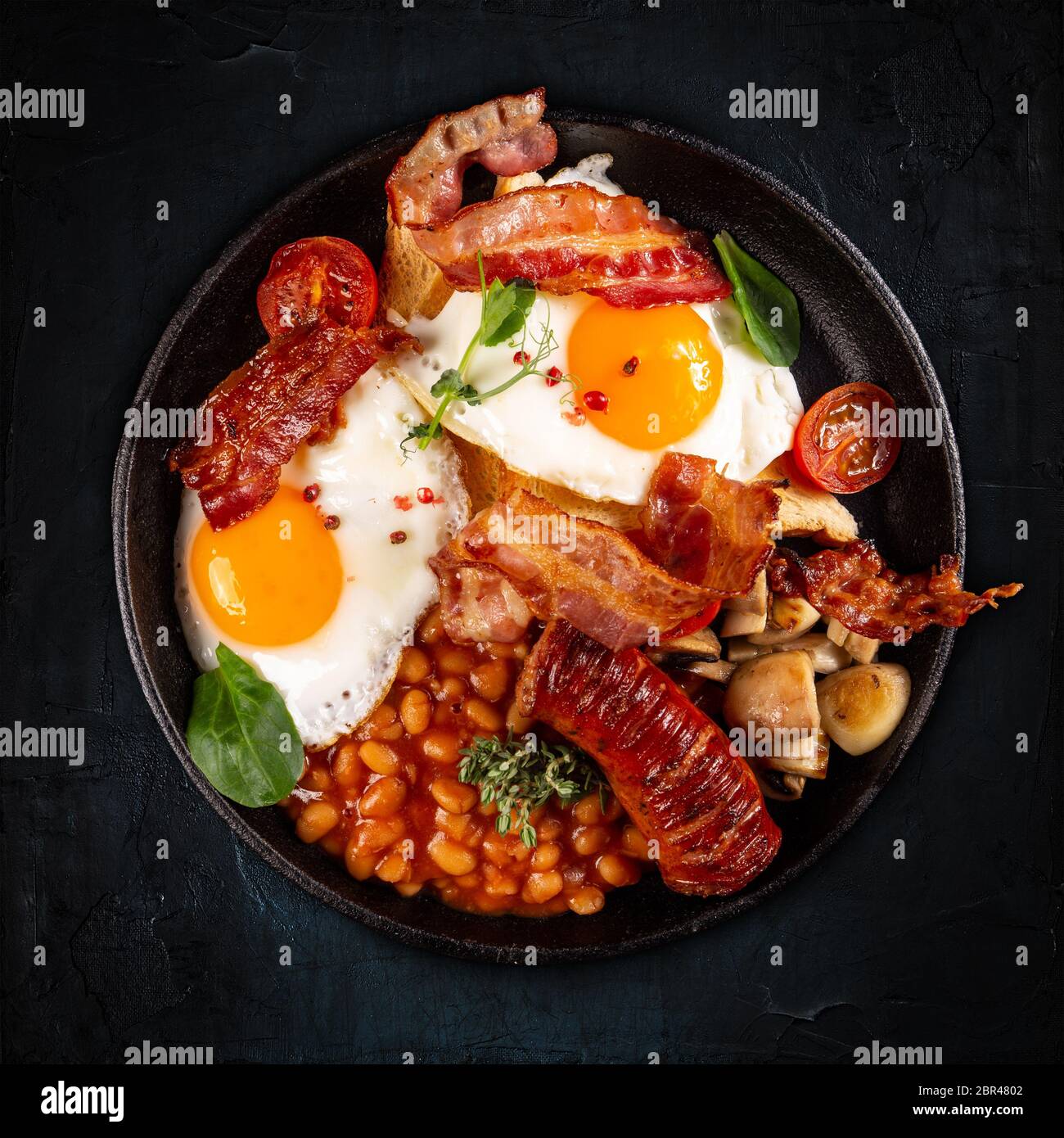 Flat lay of Full English Breakfast including sausages, grilled tomatoes