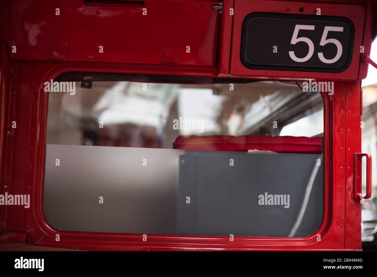 Color image of a red public transport bus with number 55. Stock Photo