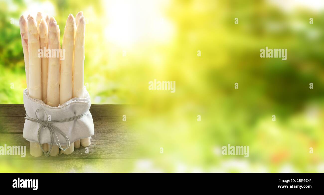 Bunch of white asparagus on old rustic wood in sunny spring Stock Photo