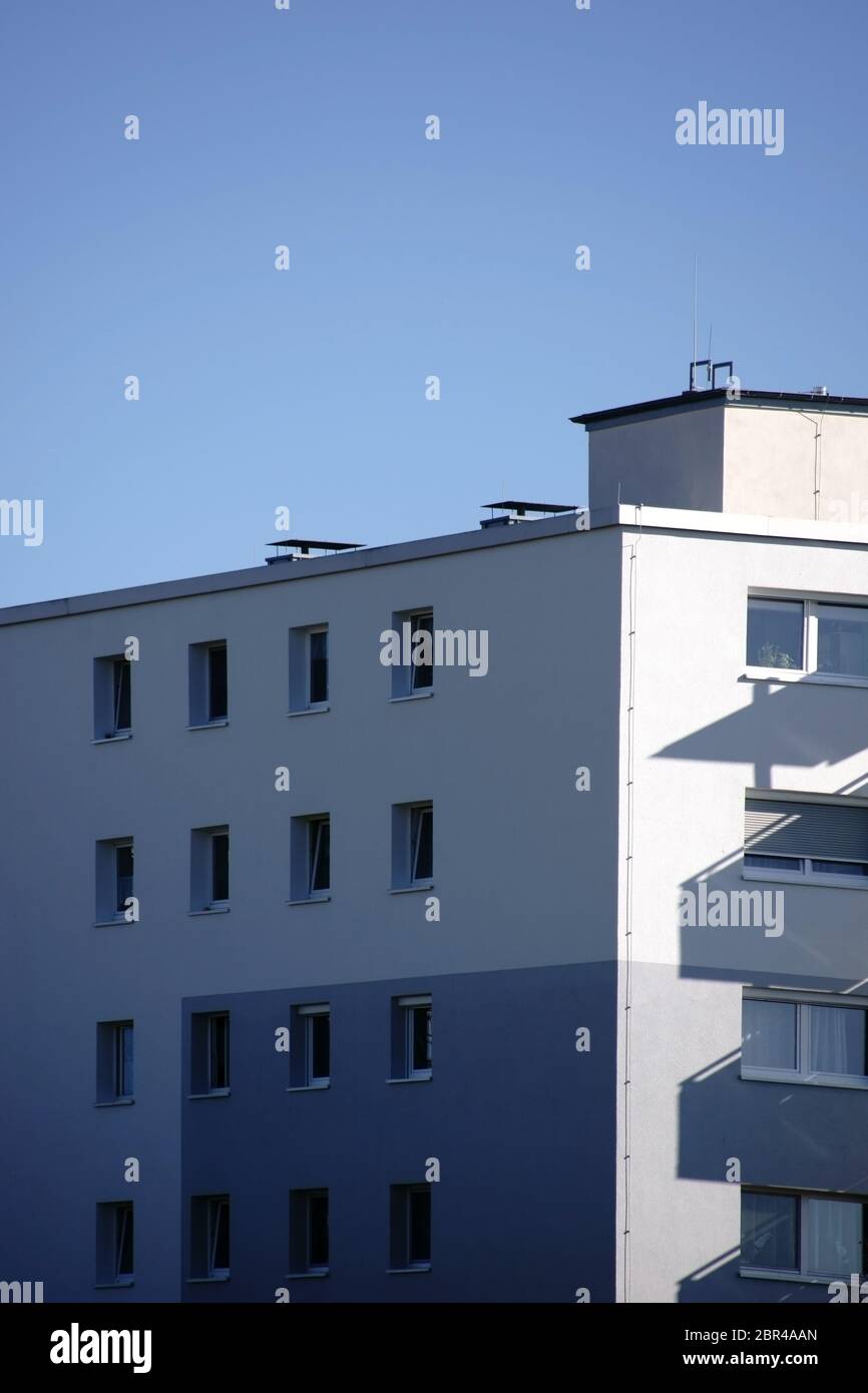 The corner of a residential building with shadows of balconies on the wall. Stock Photo