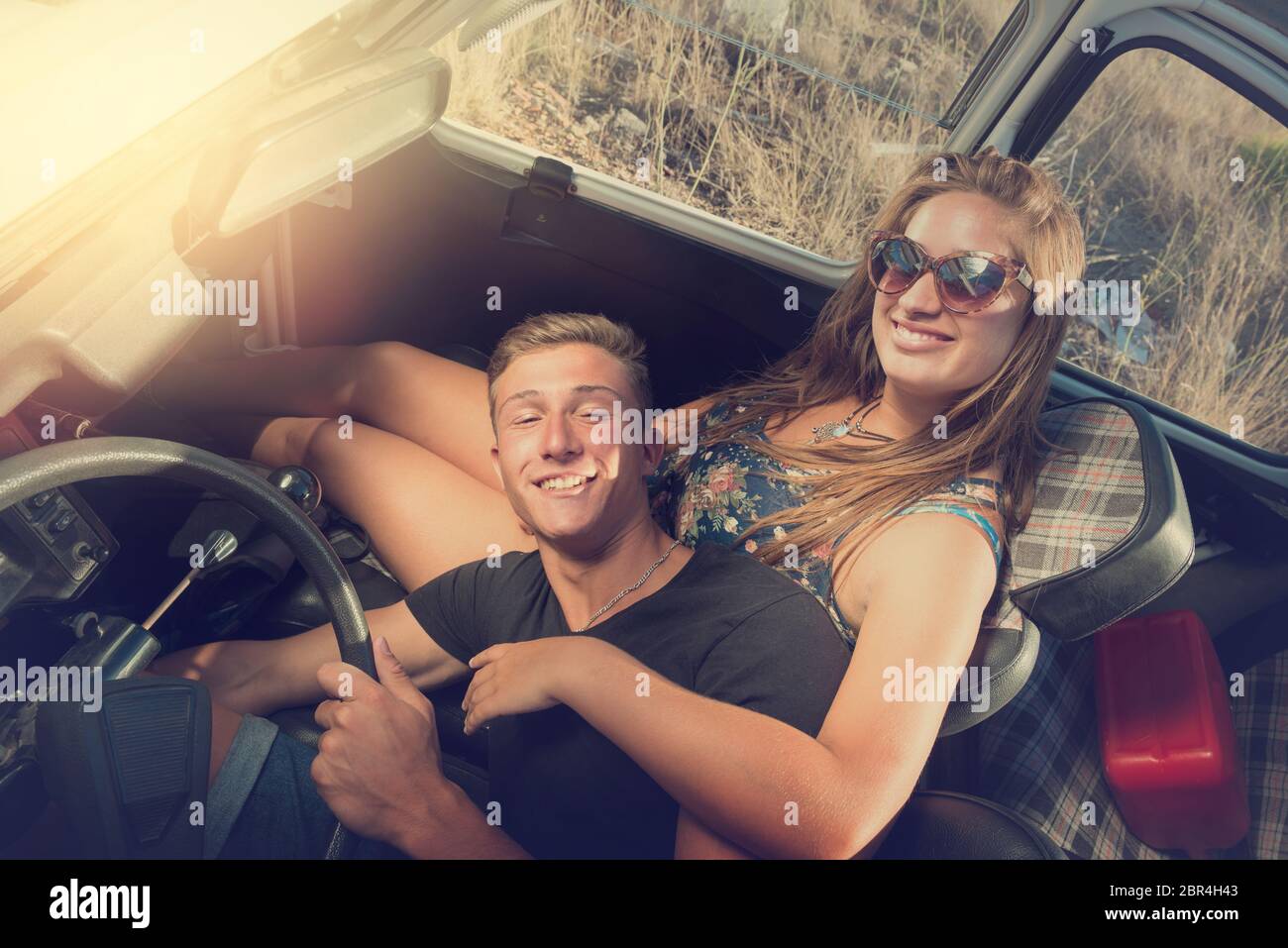 Young couple in a retro car at sunset, retro style Stock Photo - Alamy