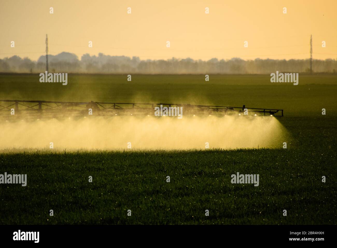 Jets of liquid fertilizer from the tractor sprayer. Tractor with the