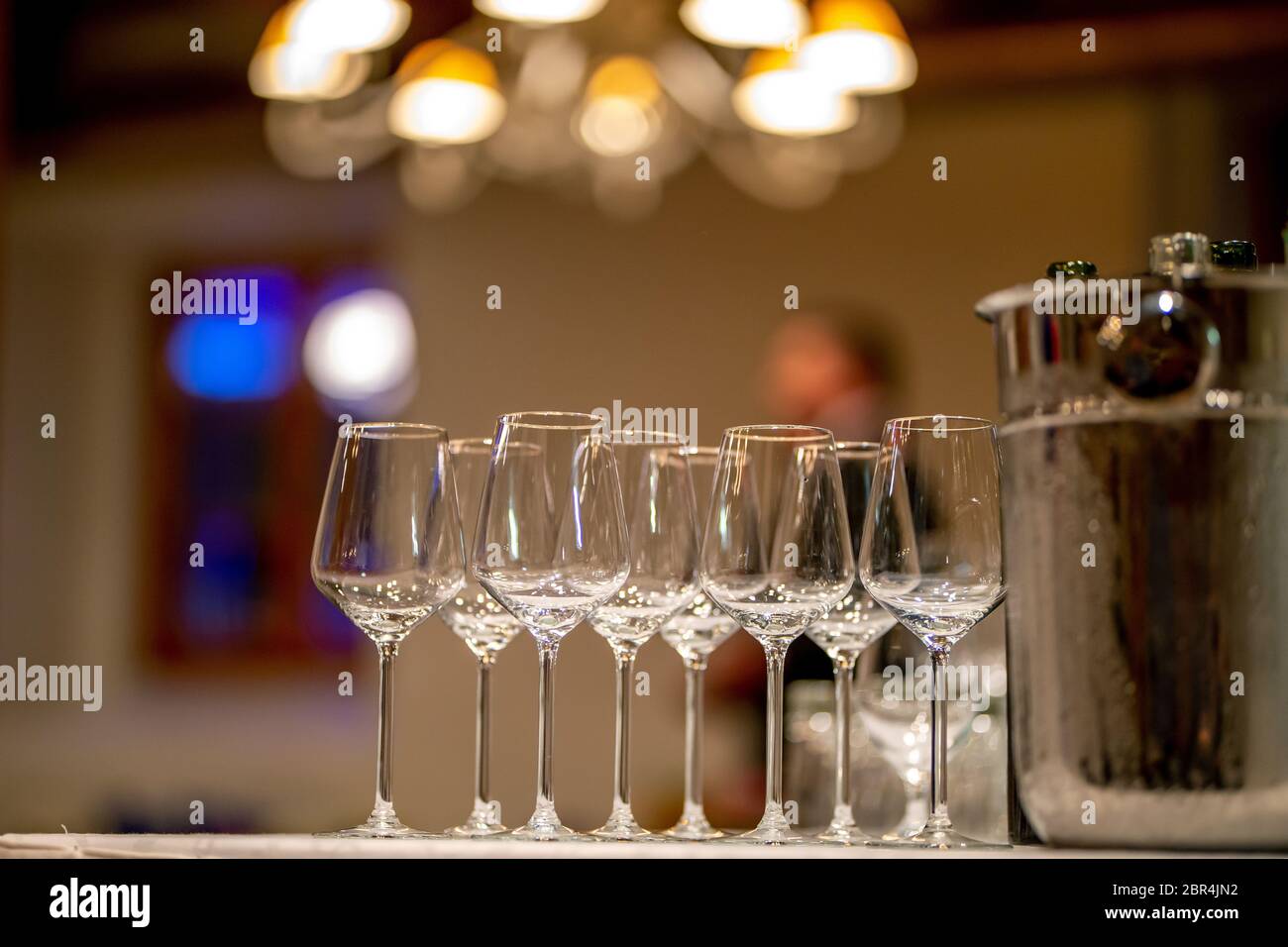 Empty glasses, wine bottles and bucket with ice on table in restaurant. Ice bucket, wine glasses and bottles arranged on the table for wedding recepti Stock Photo