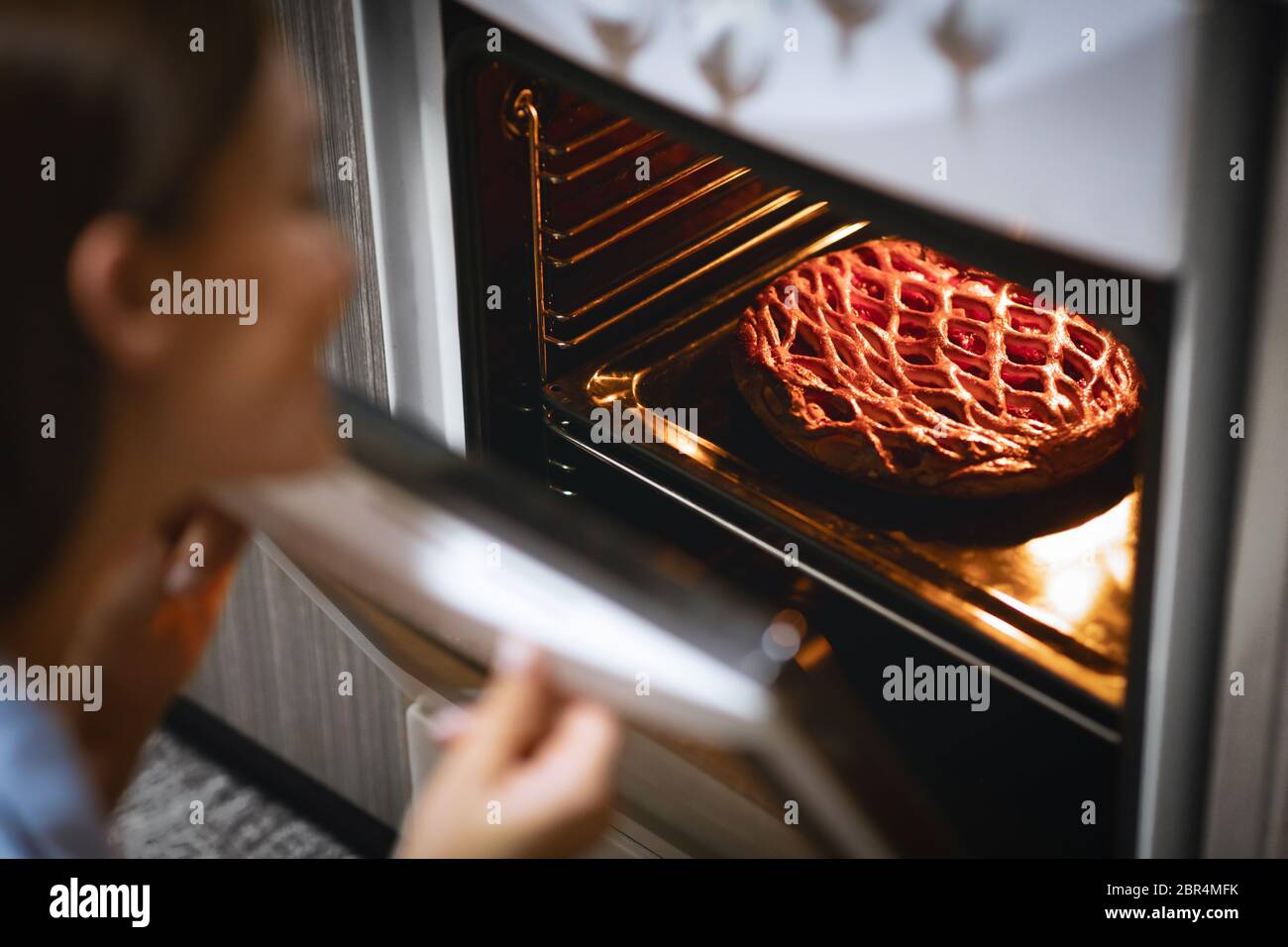 Fresh sweet pie in open oven , housewife enjoying baking Stock Photo