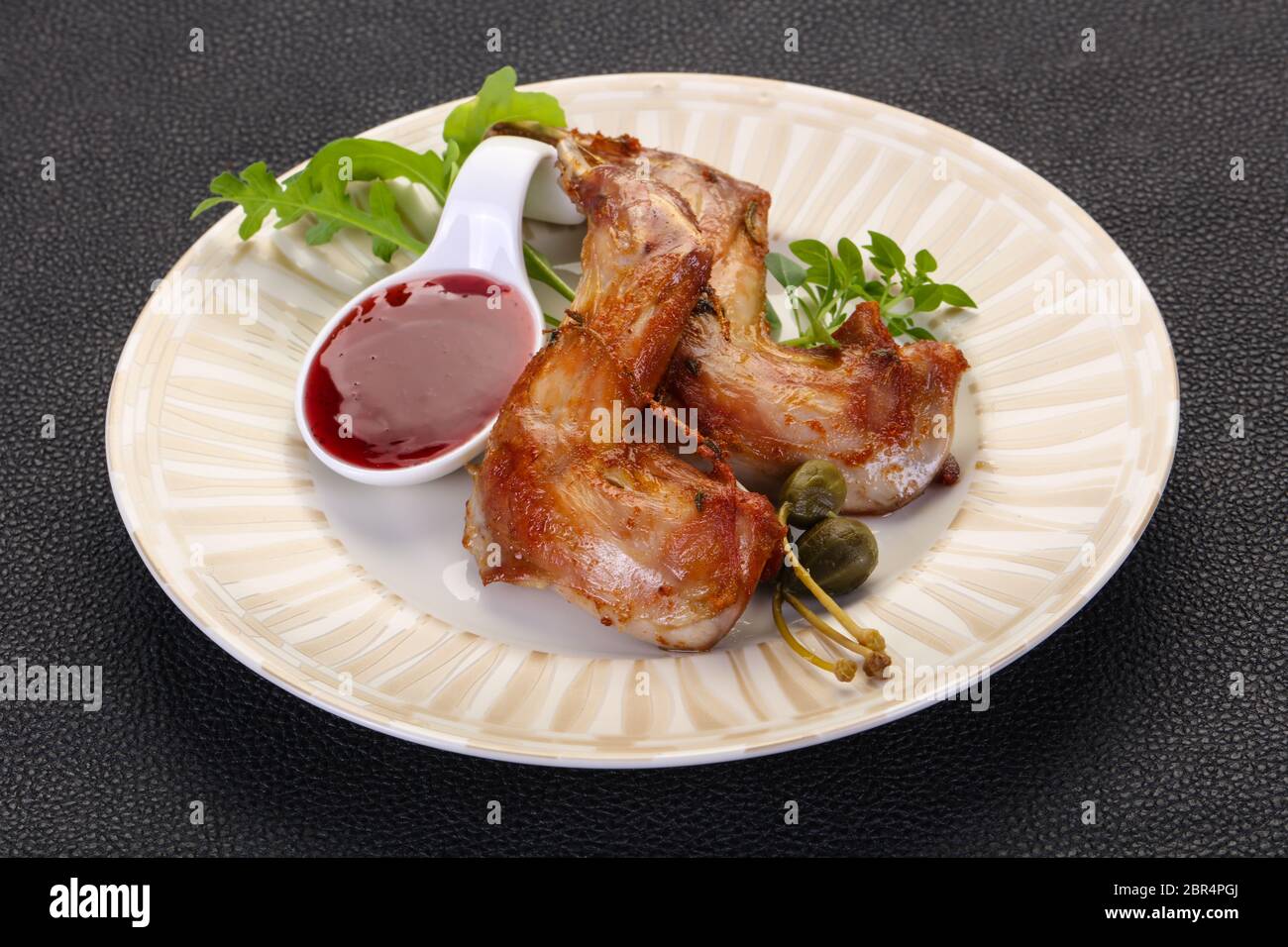 Roasted rabbit legs with cowberry sauce Stock Photo Alamy