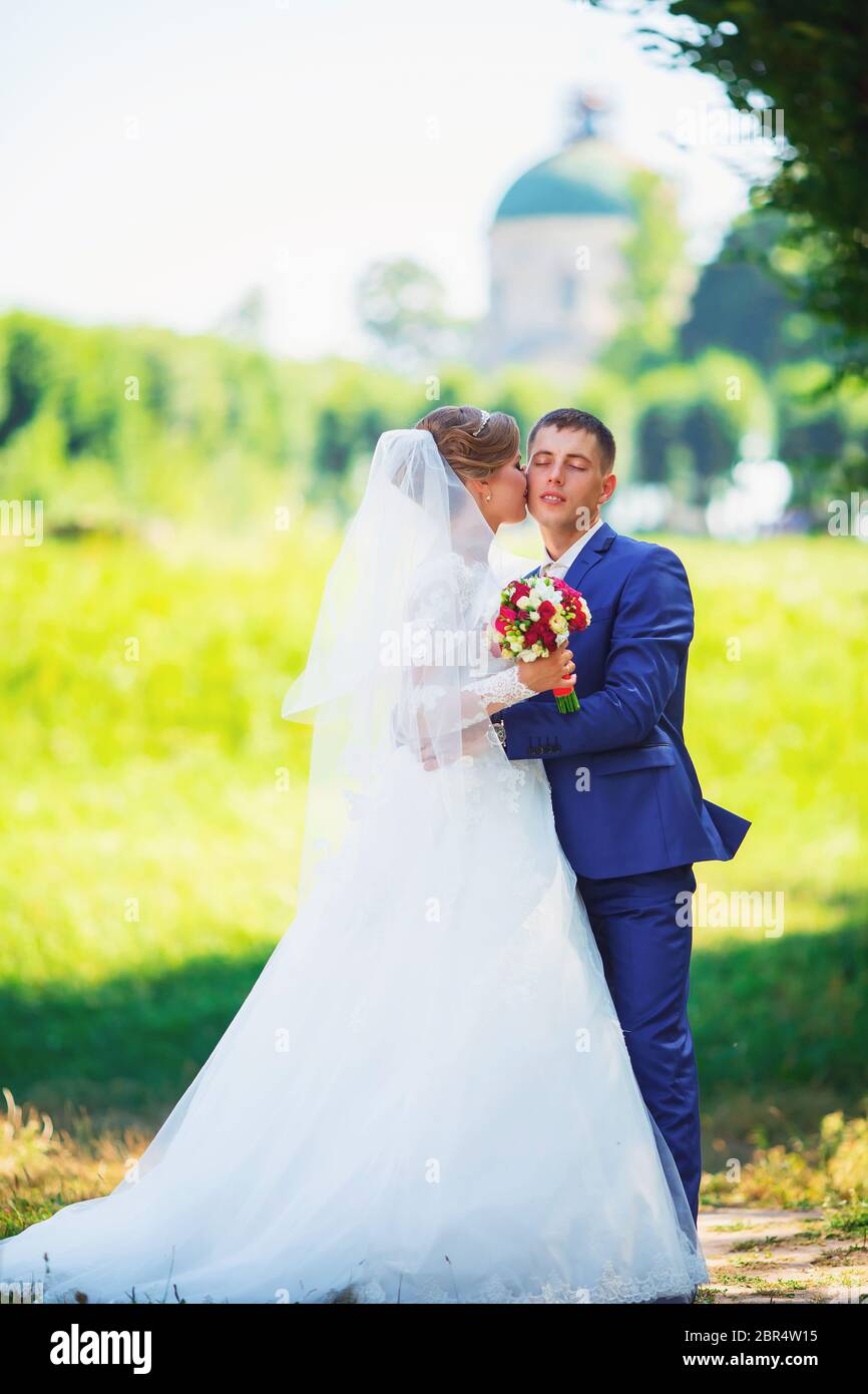Bride and groom in the park kissing. wedding in nature green forest ...