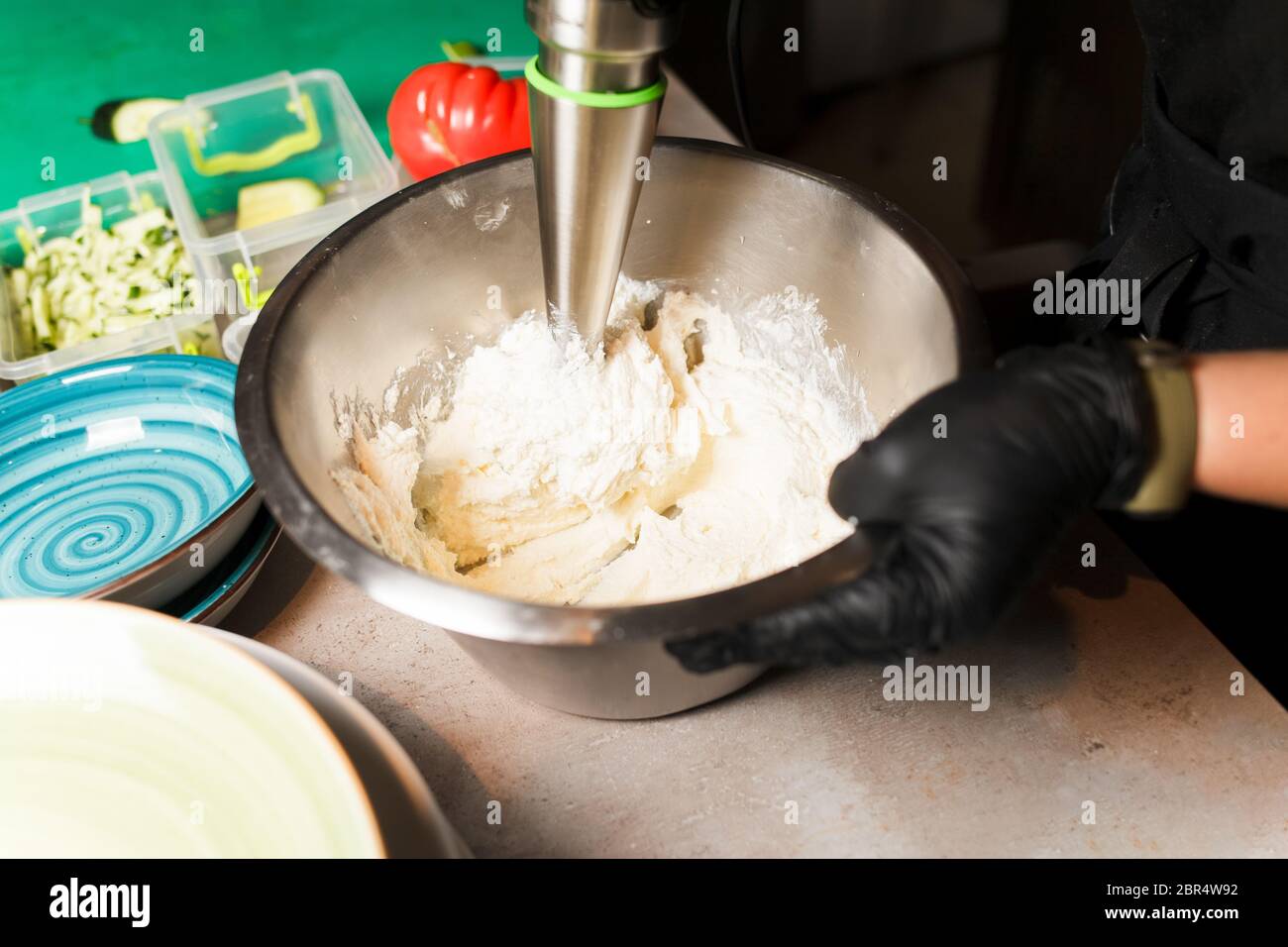 Chef making cheese mix for cheese pancake at restaurant. Blender whips the cottage cheese