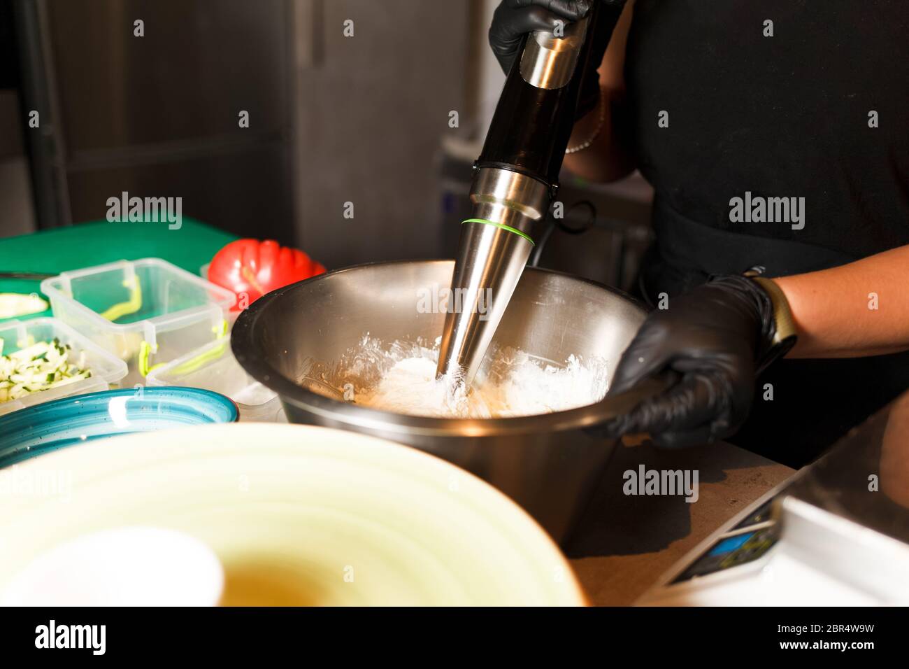 Chef making cheese mix for cheese pancake at restaurant. Blender whips the cottage cheese