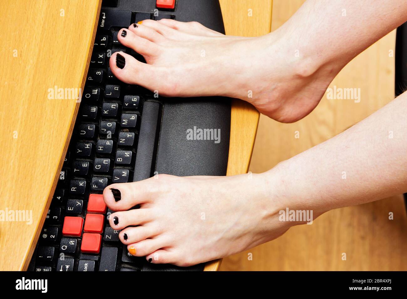Woman legs on computer keyboard in office Stock Photo Alamy
