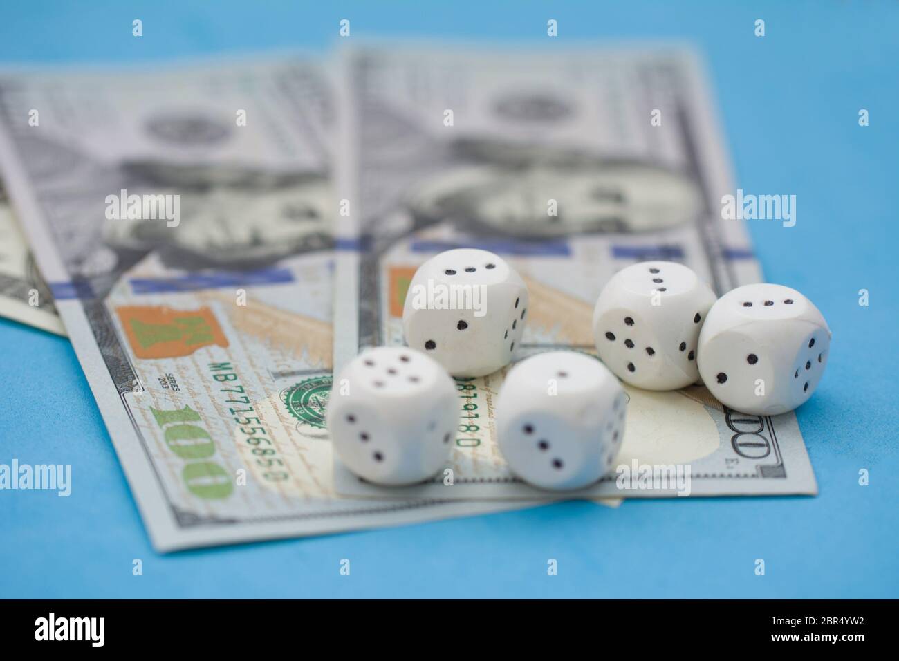 Game dice and hundred dollar bills on blue background. Board game, gambling, casino concept
