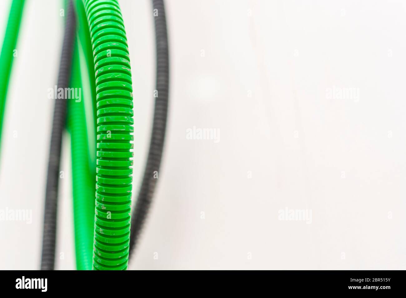 Black and green corrugated bellow conduit tube for electrical wiring Stock Photo