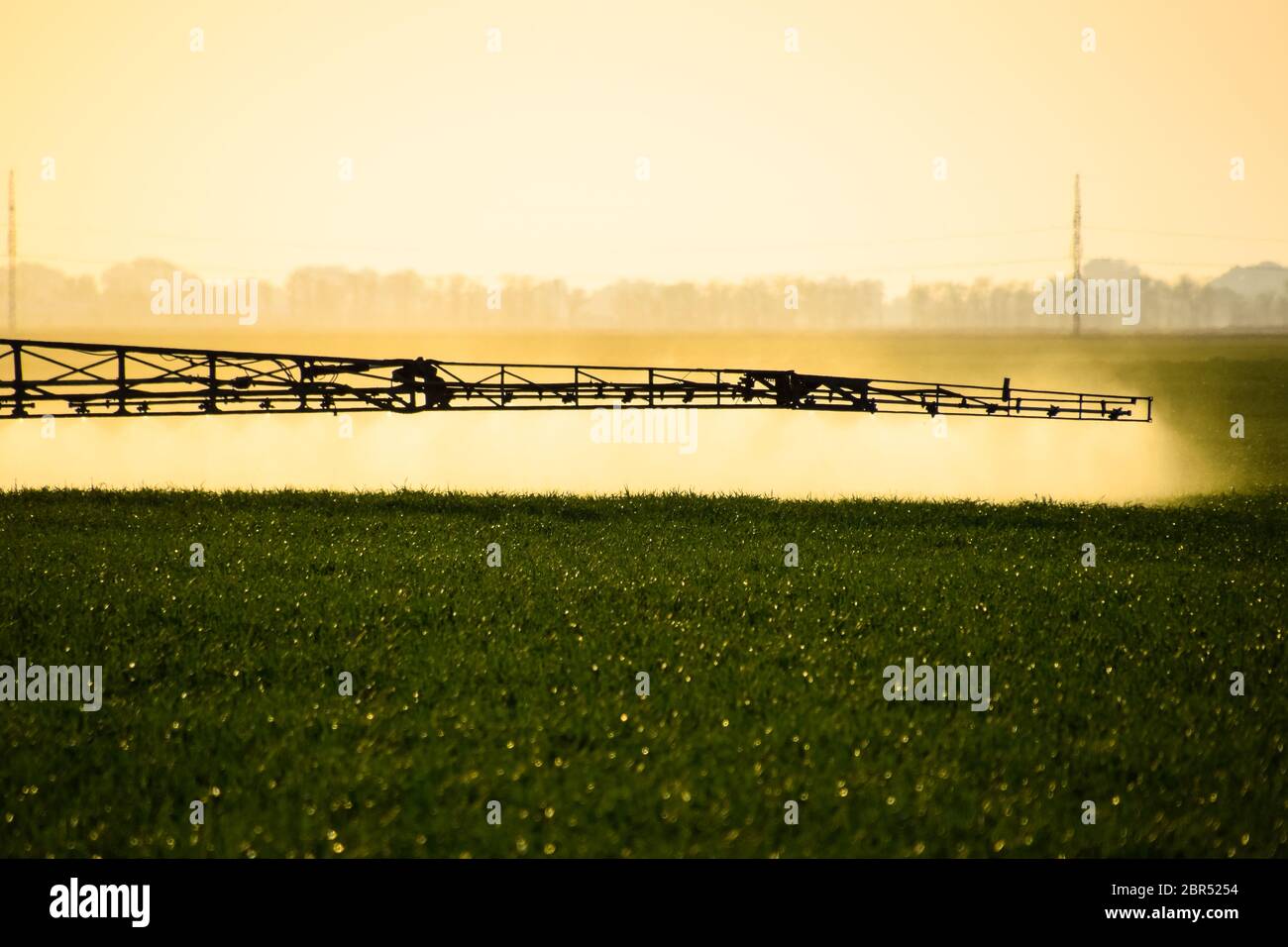 Jets of liquid fertilizer from the tractor sprayer. Tractor with the