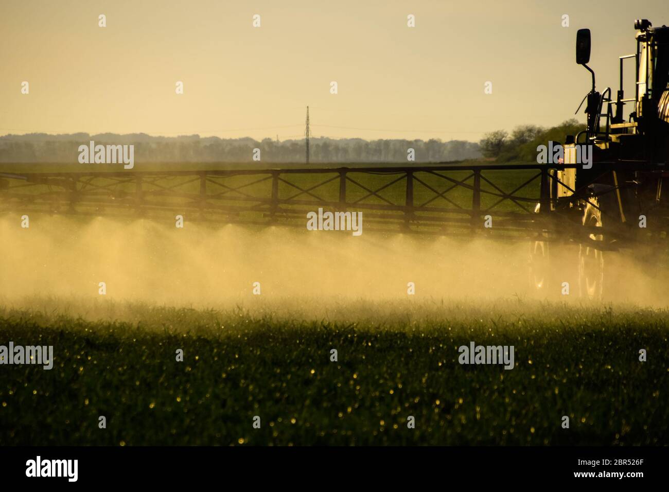 Jets of liquid fertilizer from the tractor sprayer. Tractor with the