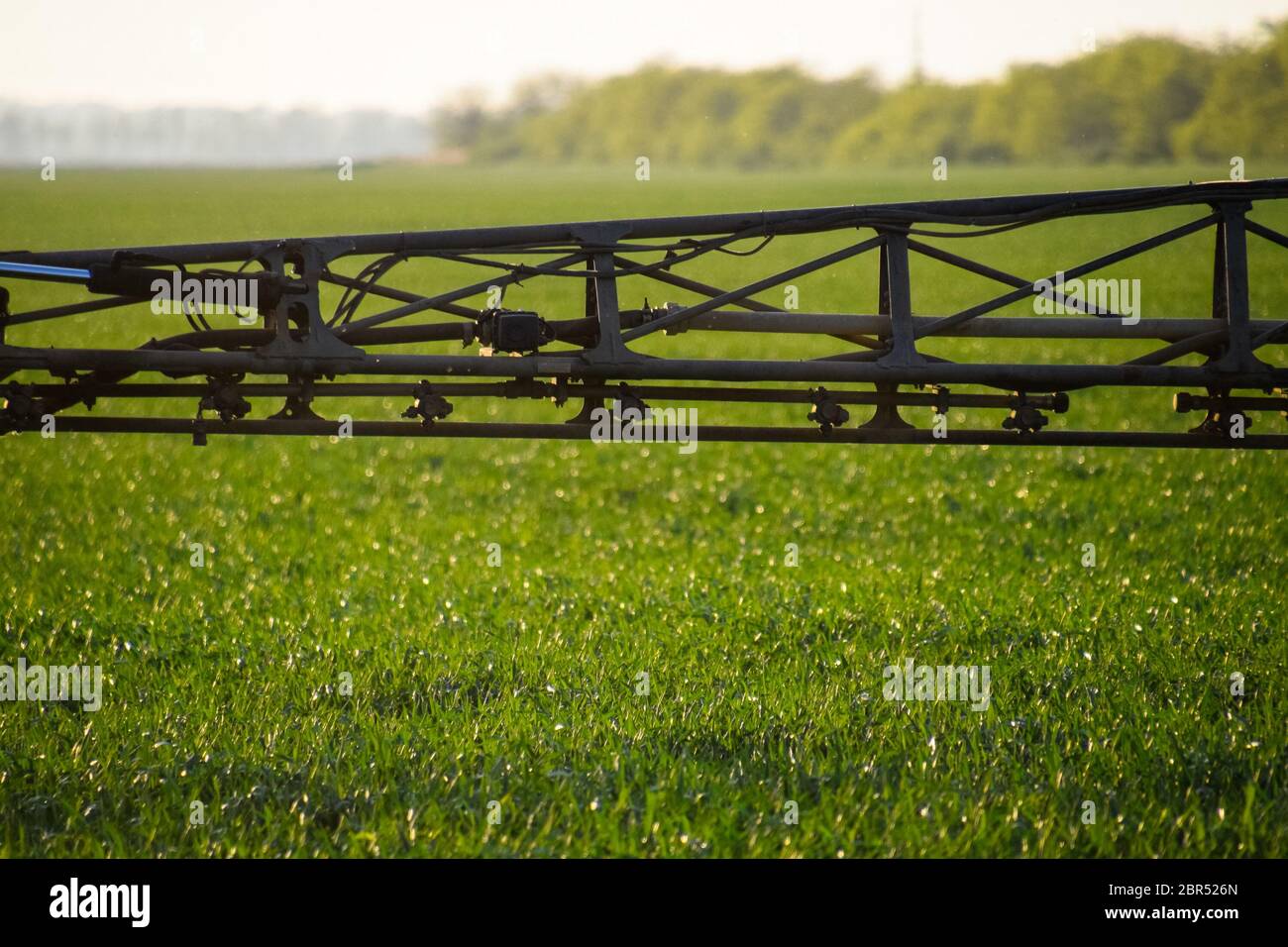 Jets of liquid fertilizer from the tractor sprayer. Tractor with the