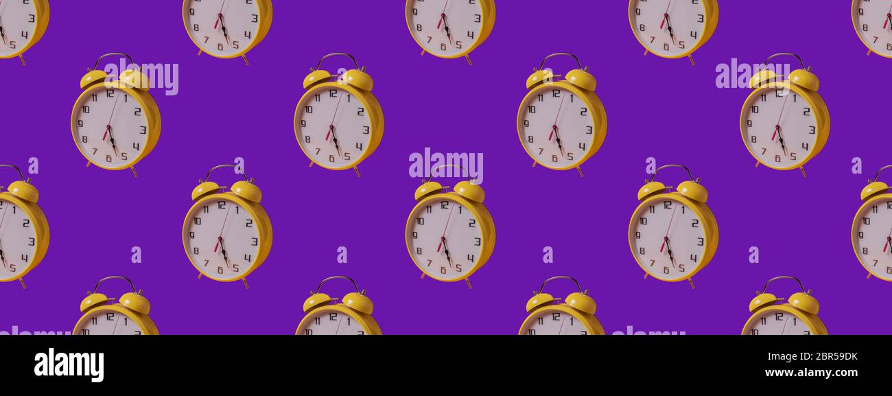 Seamless Pattern made with yellow clock image on purple paper background. Stock Photo