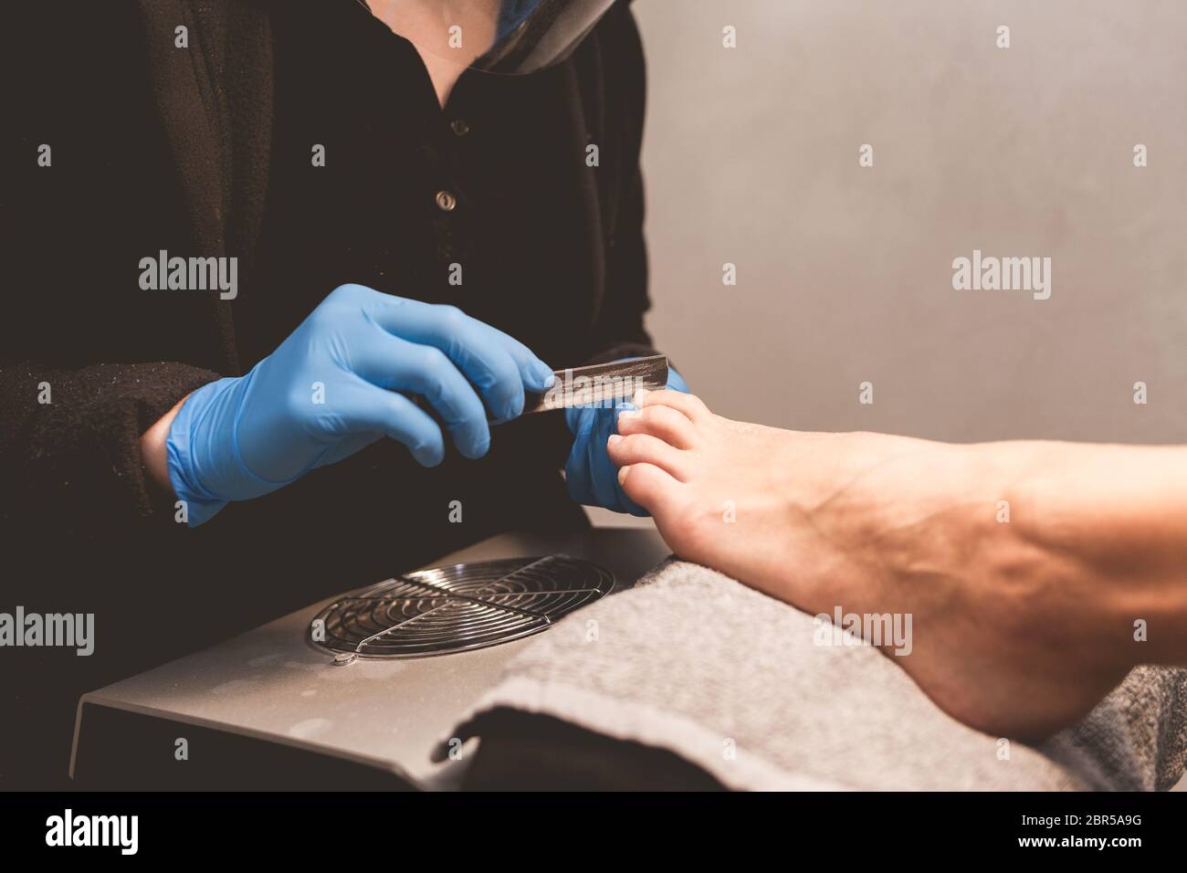Pedicure master files nails with a nail file for subsequent application