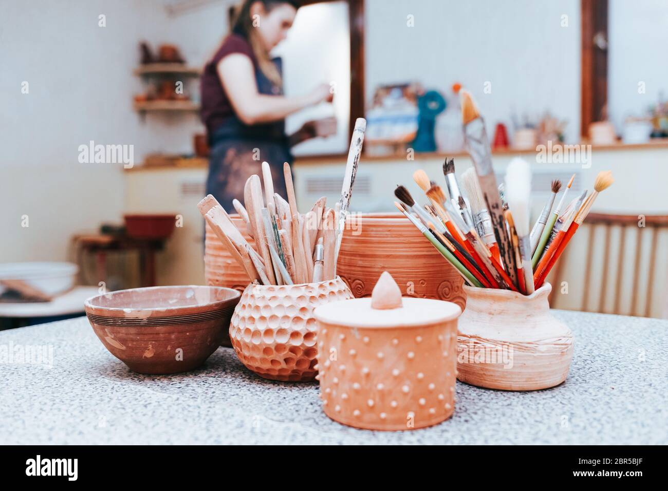 Ceramics master prepares to paint pottery. Potter in the Stock