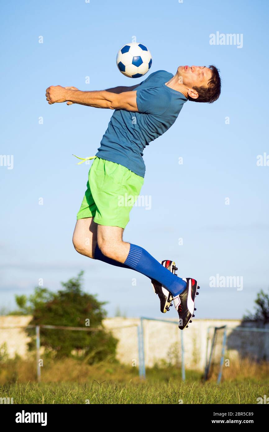 Sport moment of jumping soccer player with soccer ball in air, action