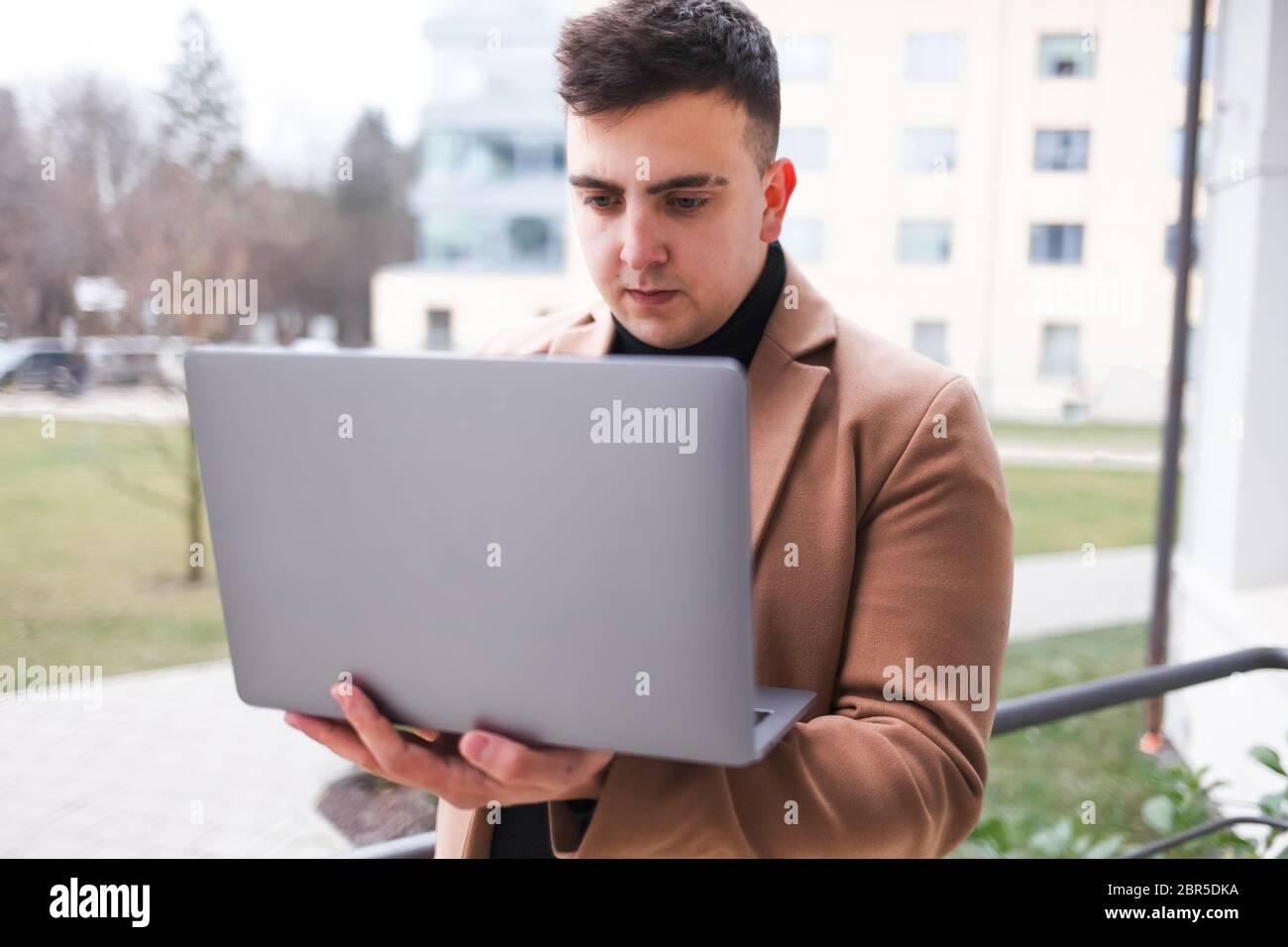 Concentrated young guy looking at a laptop Stock Photo