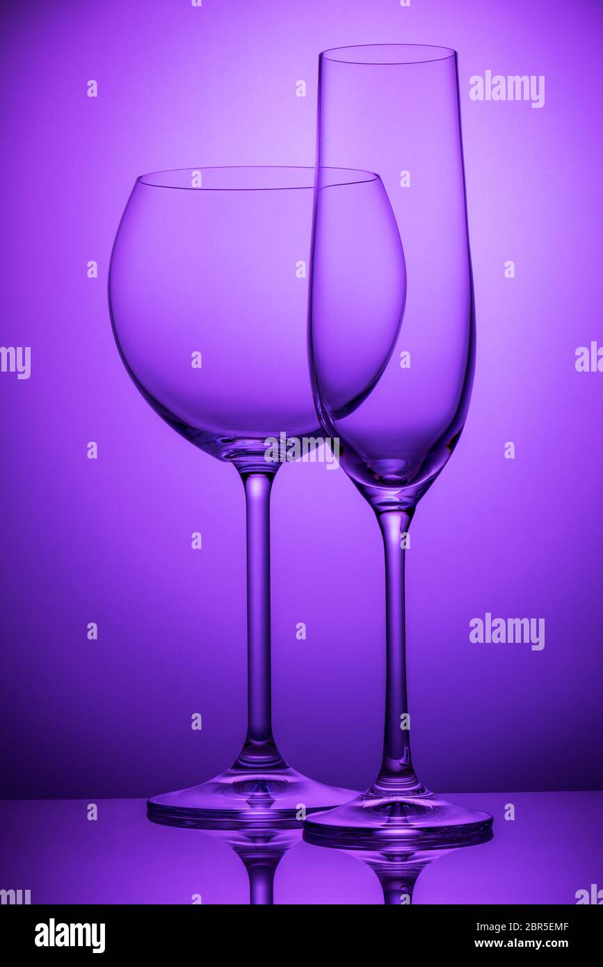 Two empty wineglasses on a purple background Stock Photo