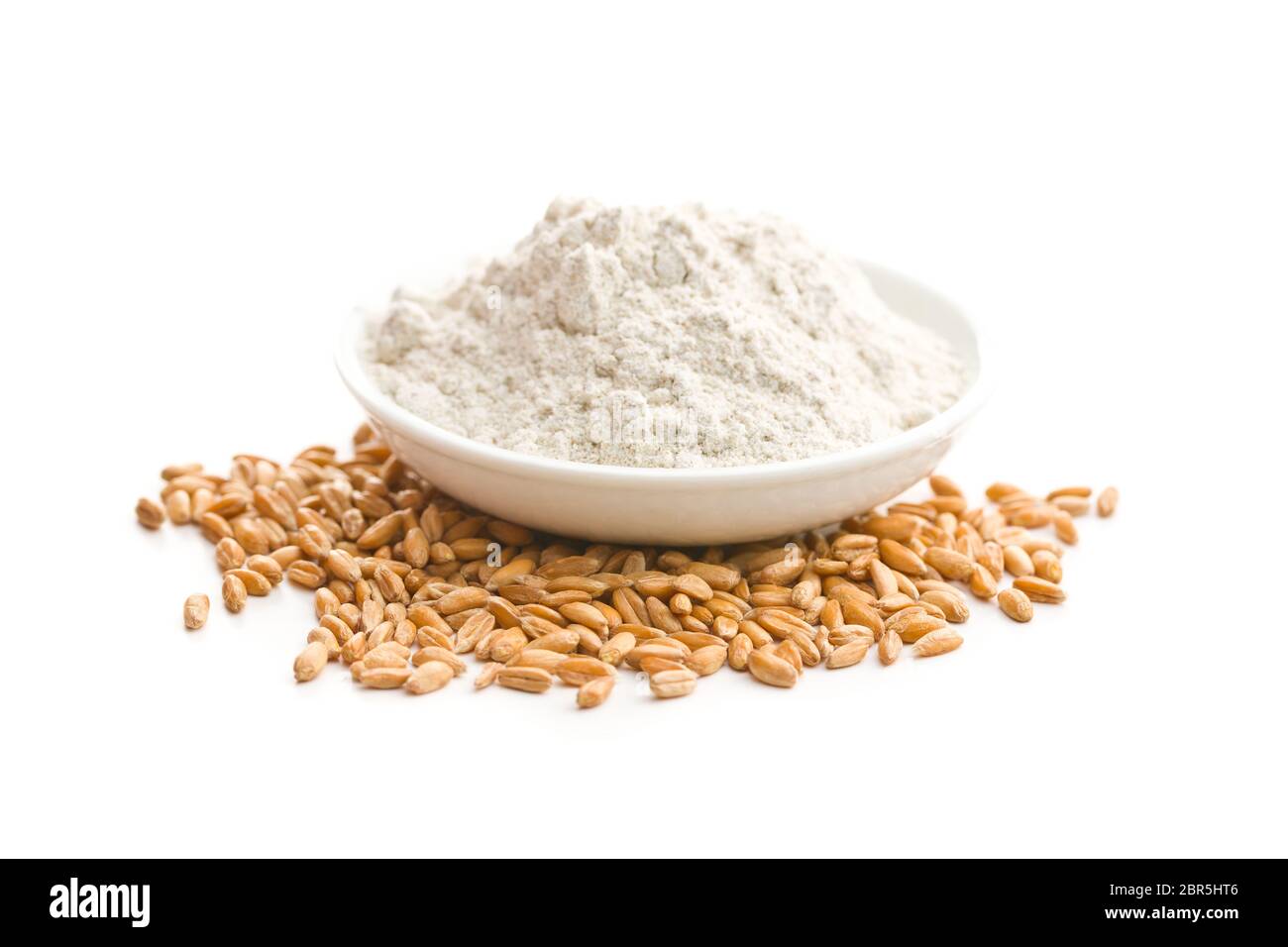 Whole grain wheat flour and wheat grains in bowl isolated on white