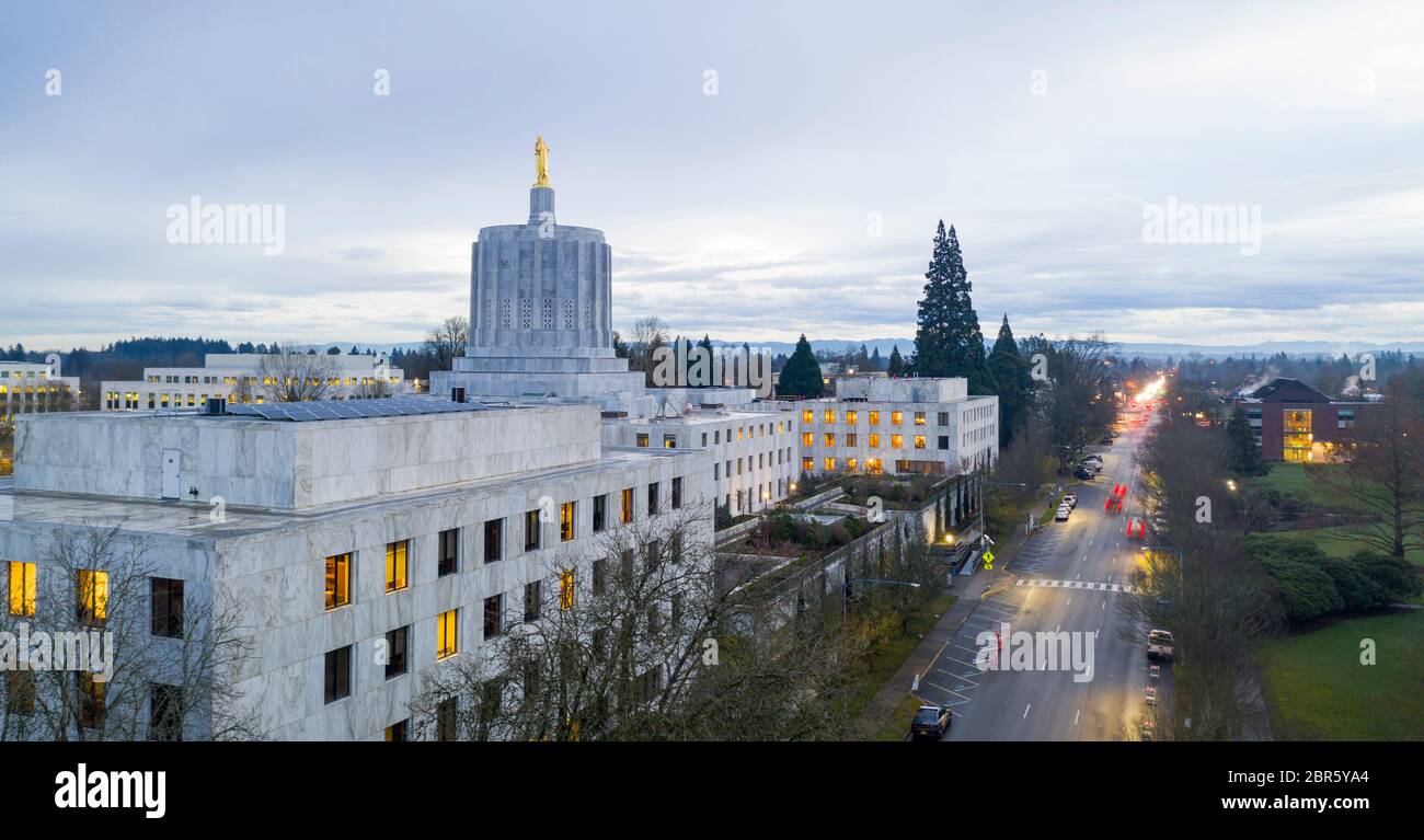 The state capital building adorned with the Oregon Pioneer with downtown Salem in the background
