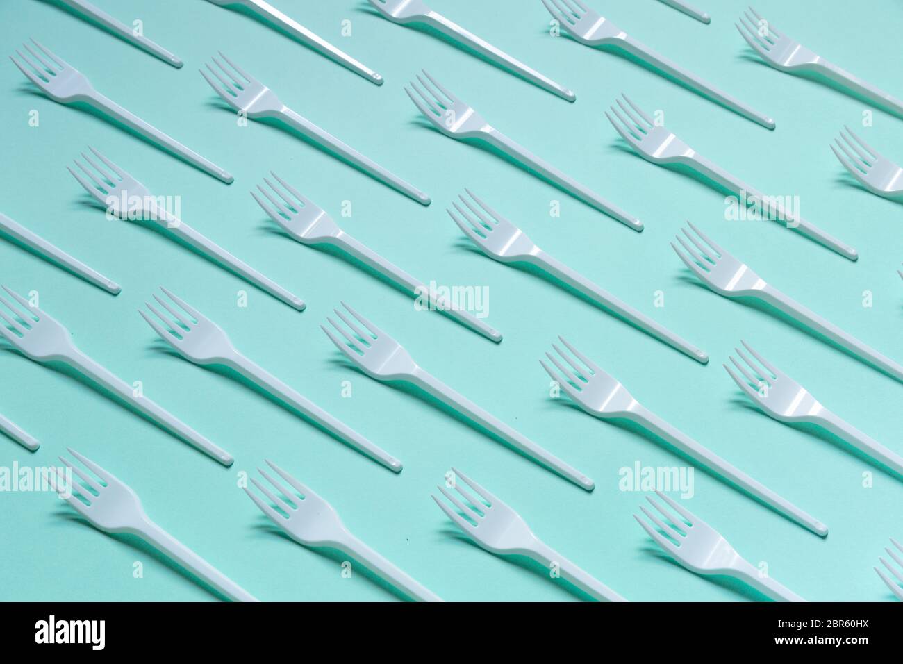 Plastic white forks on pastel blue background Stock Photo