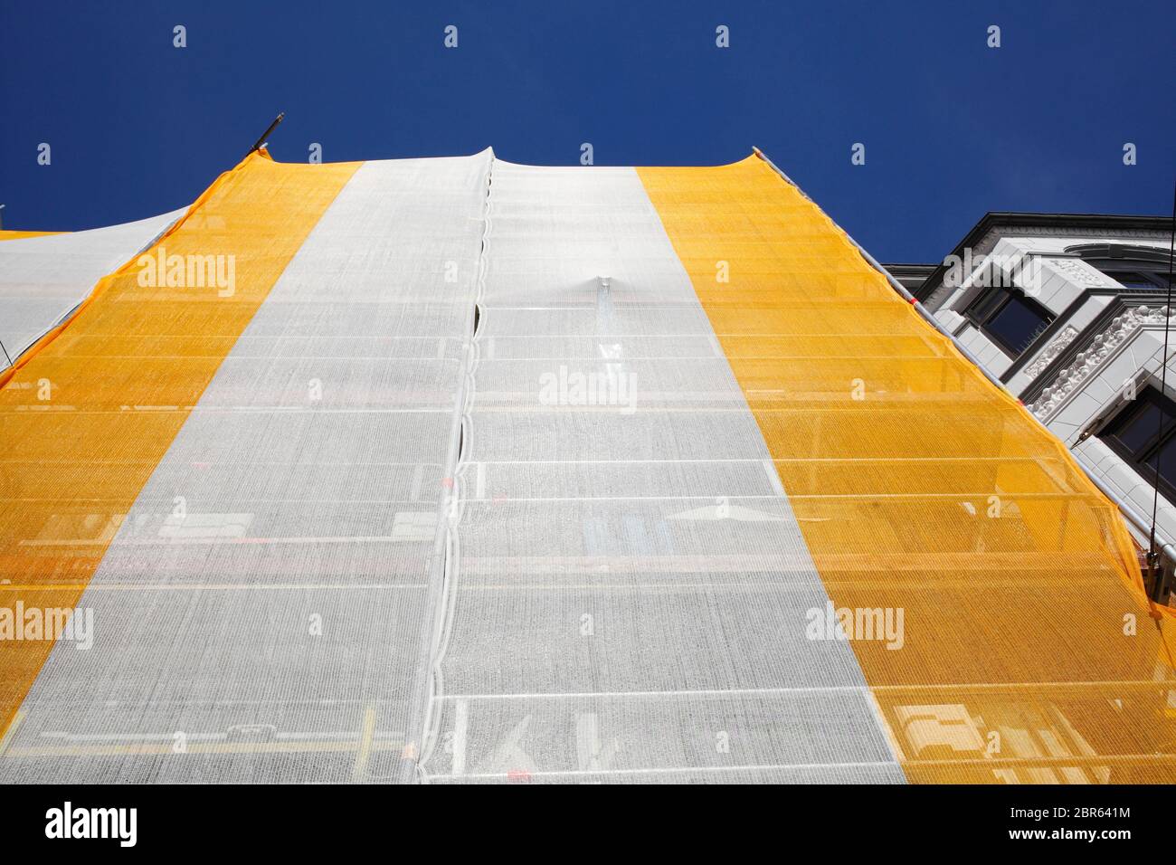 Orange-white tarpaulin, gable, scaffolding, construction site, house facade, old building, Germany, Europe Stock Photo