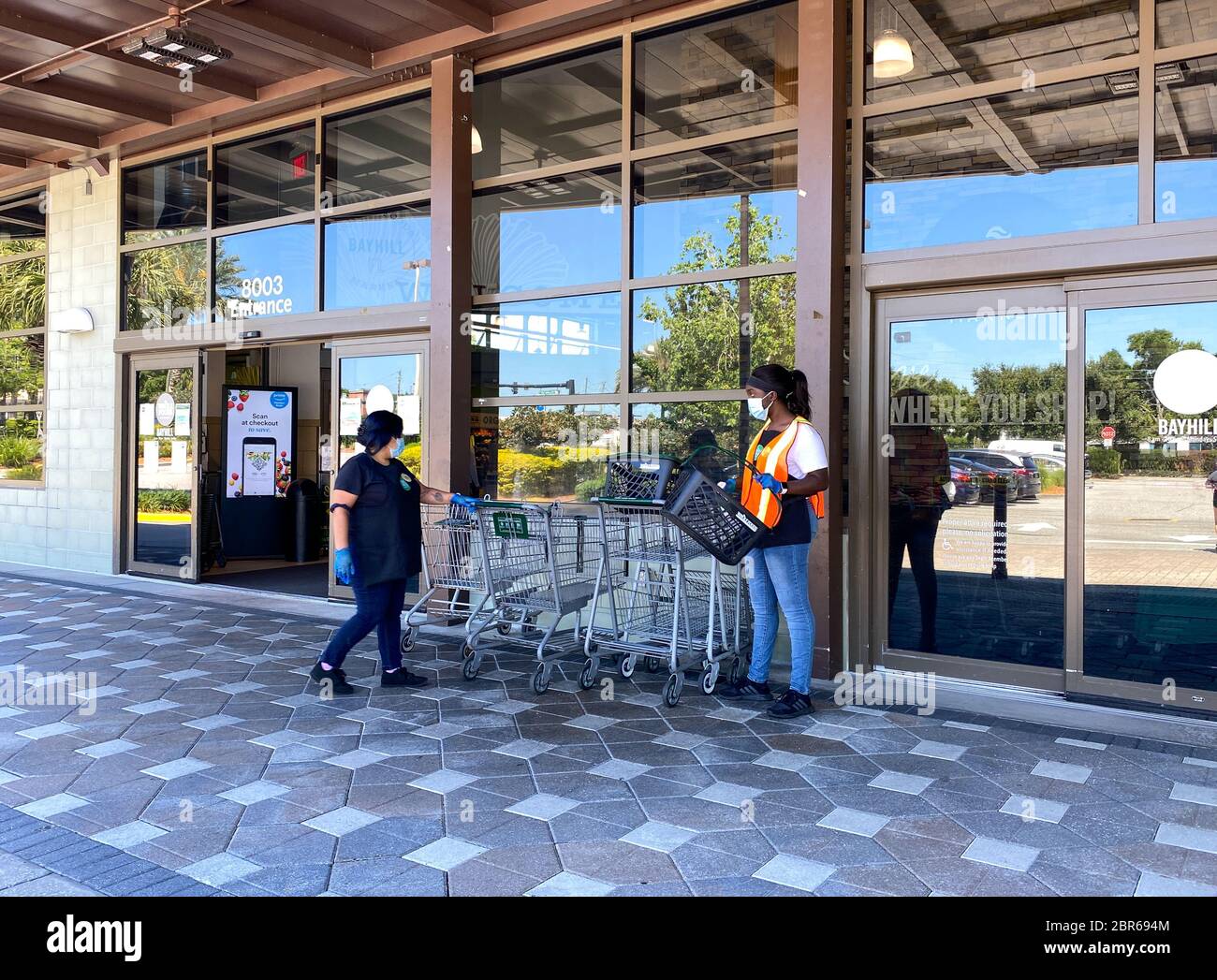 Orlando, FL/USA5/3/20 Employees sanitizing grocery baskets and carts