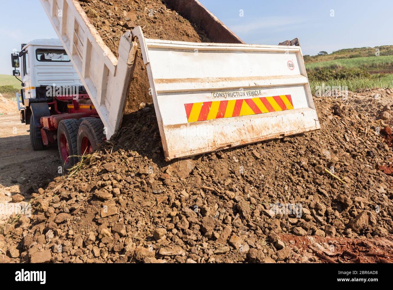 Construction Truck vehicle bucket bin tipping offloading earth closeup ...