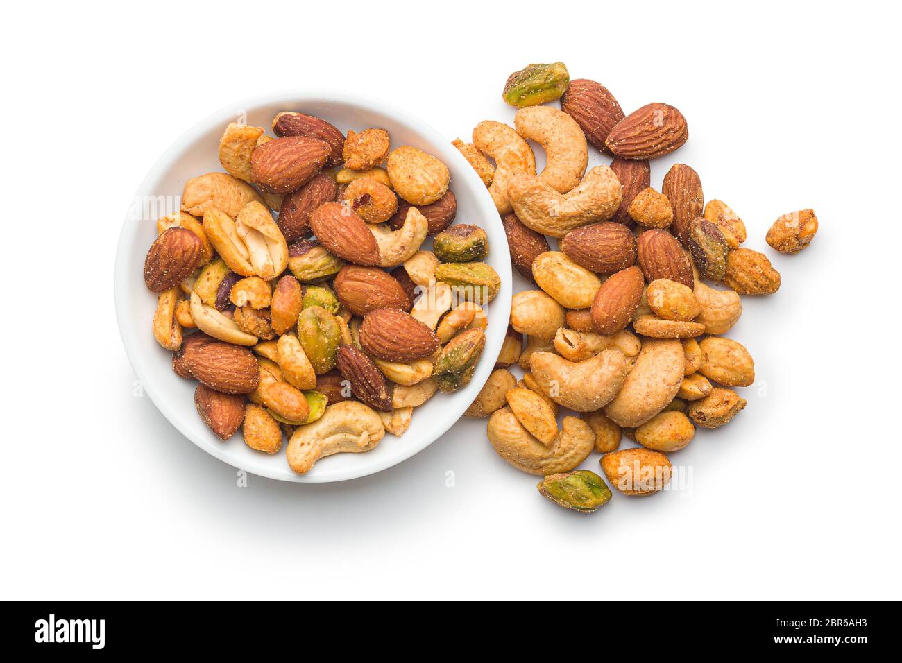 Spicy flavoured nuts. Mix of nuts in bowl isolated on white background. Stock Photo