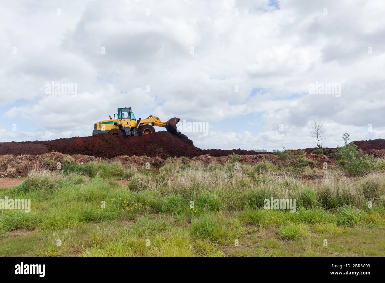 Industrial earthworks loader bucket machine on building construction site. Stock Photo