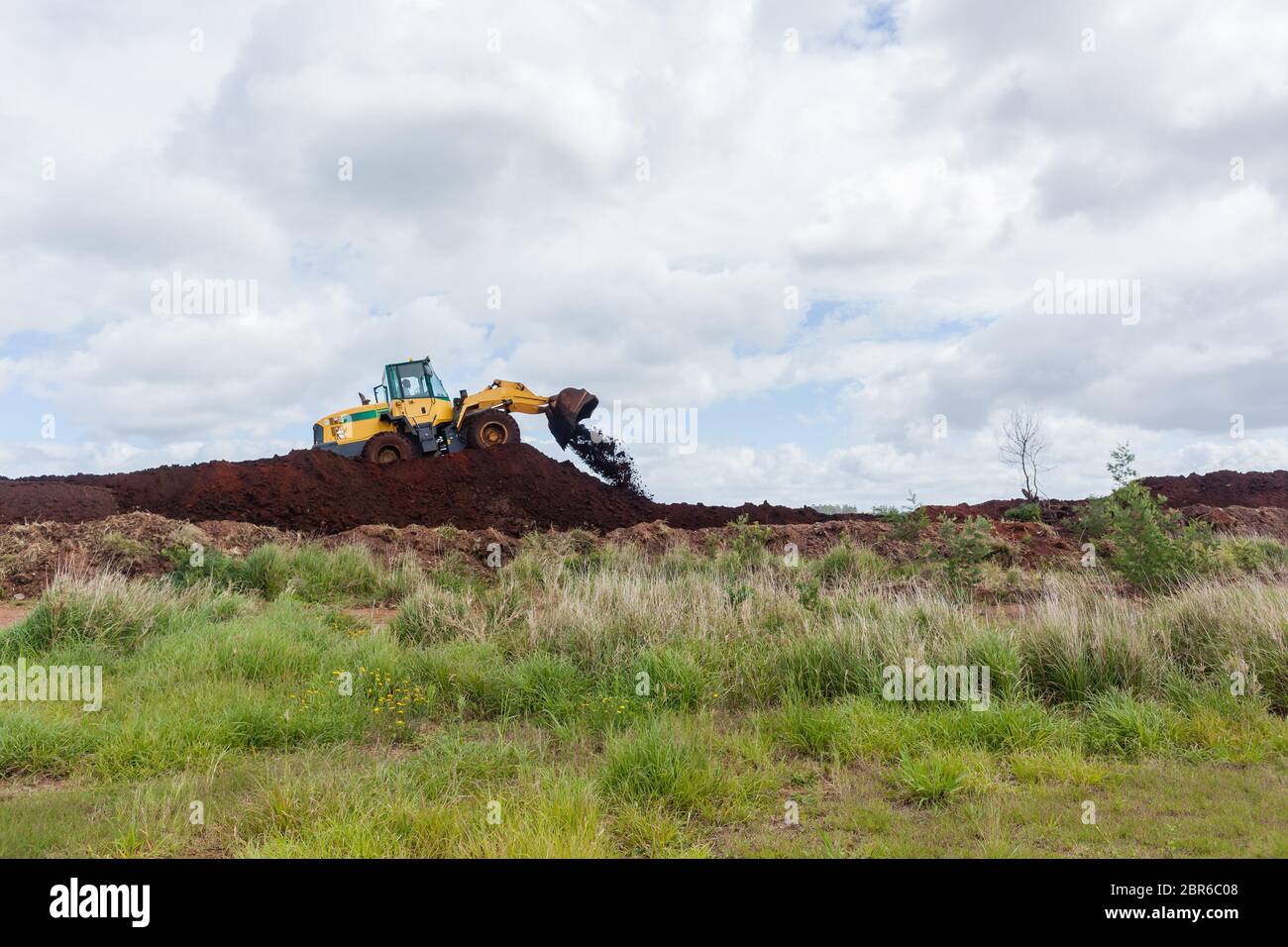 Industrial earthworks loader bucket machine on building construction site. Stock Photo