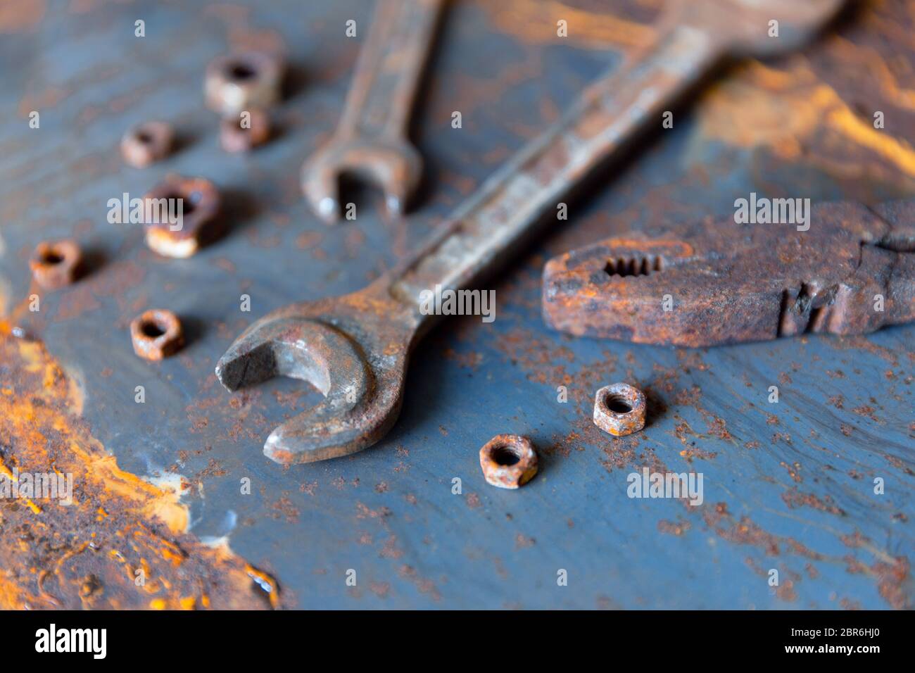 Old rusty wrench over battered metal table rough style. Wrenches top view for construction, industrial, electrician concept design Stock Photo