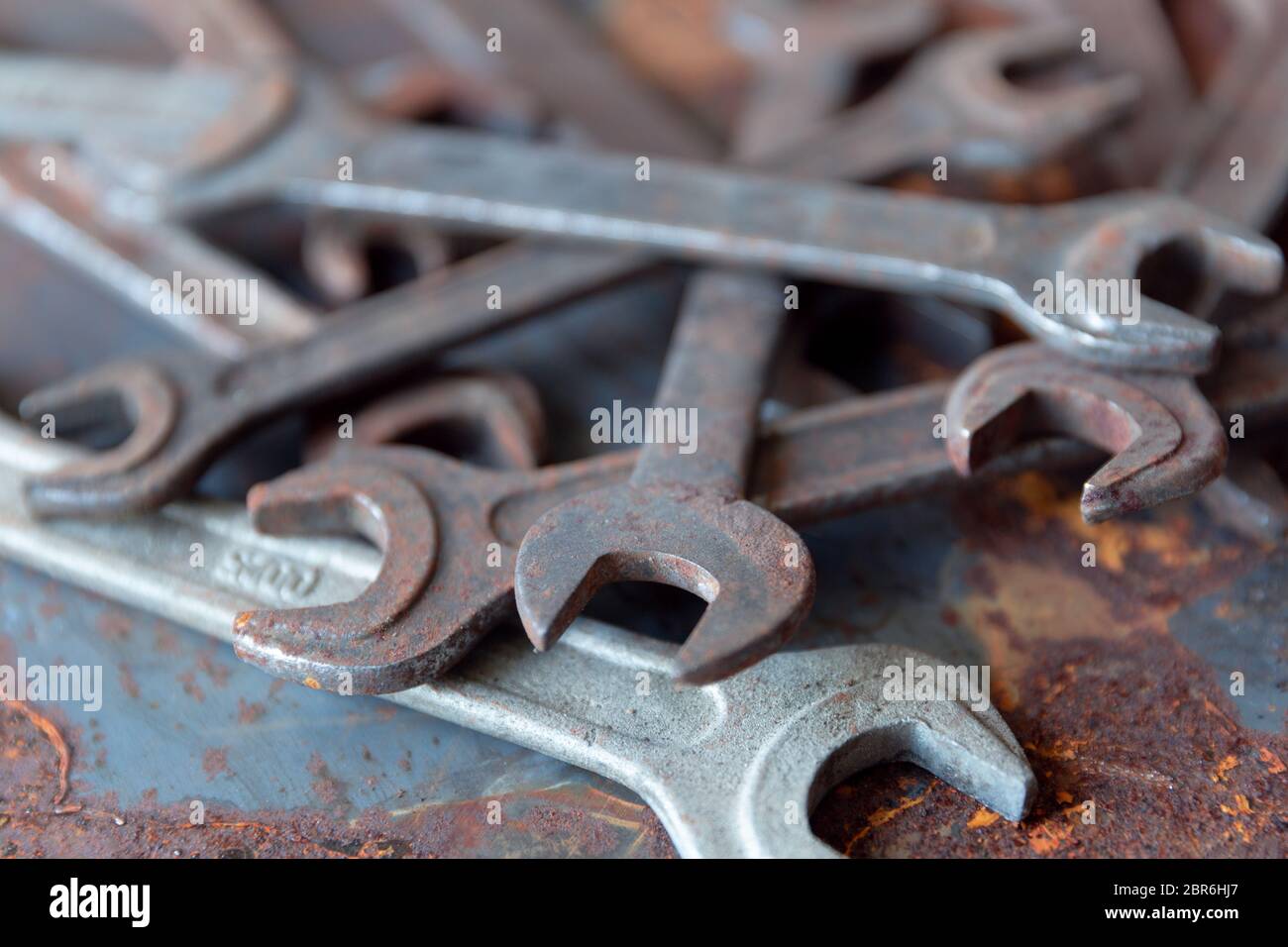 Old rusty wrench over battered metal table rough style. Wrenches top view for construction, industrial, electrician concept design Stock Photo