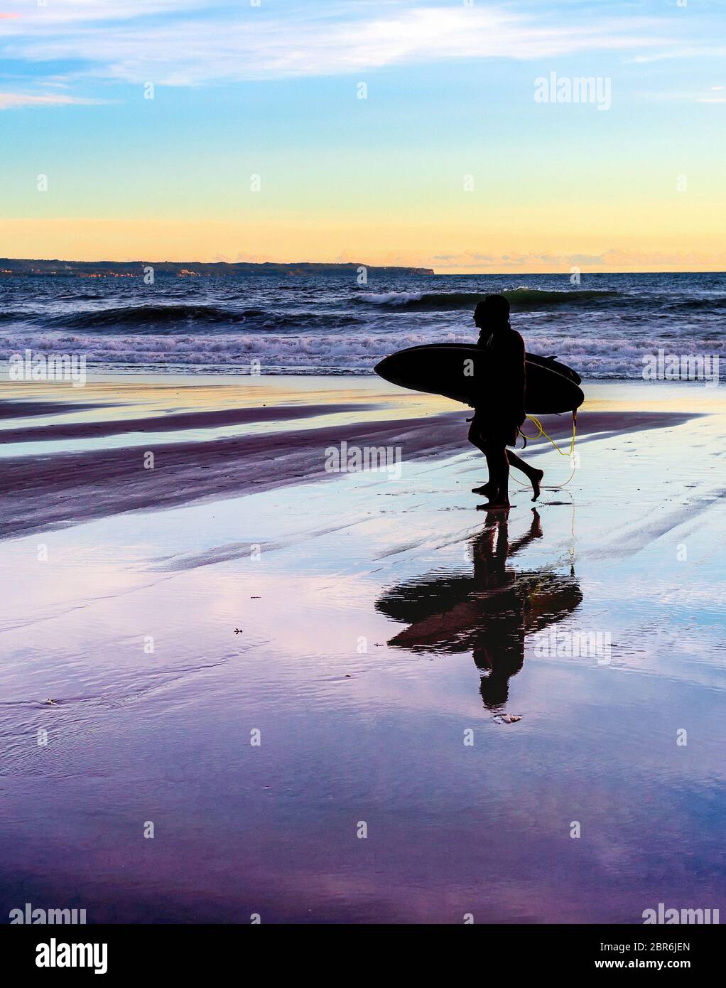 Couple with surfboards at sunset ocean coast, Bali, Indonesia Stock