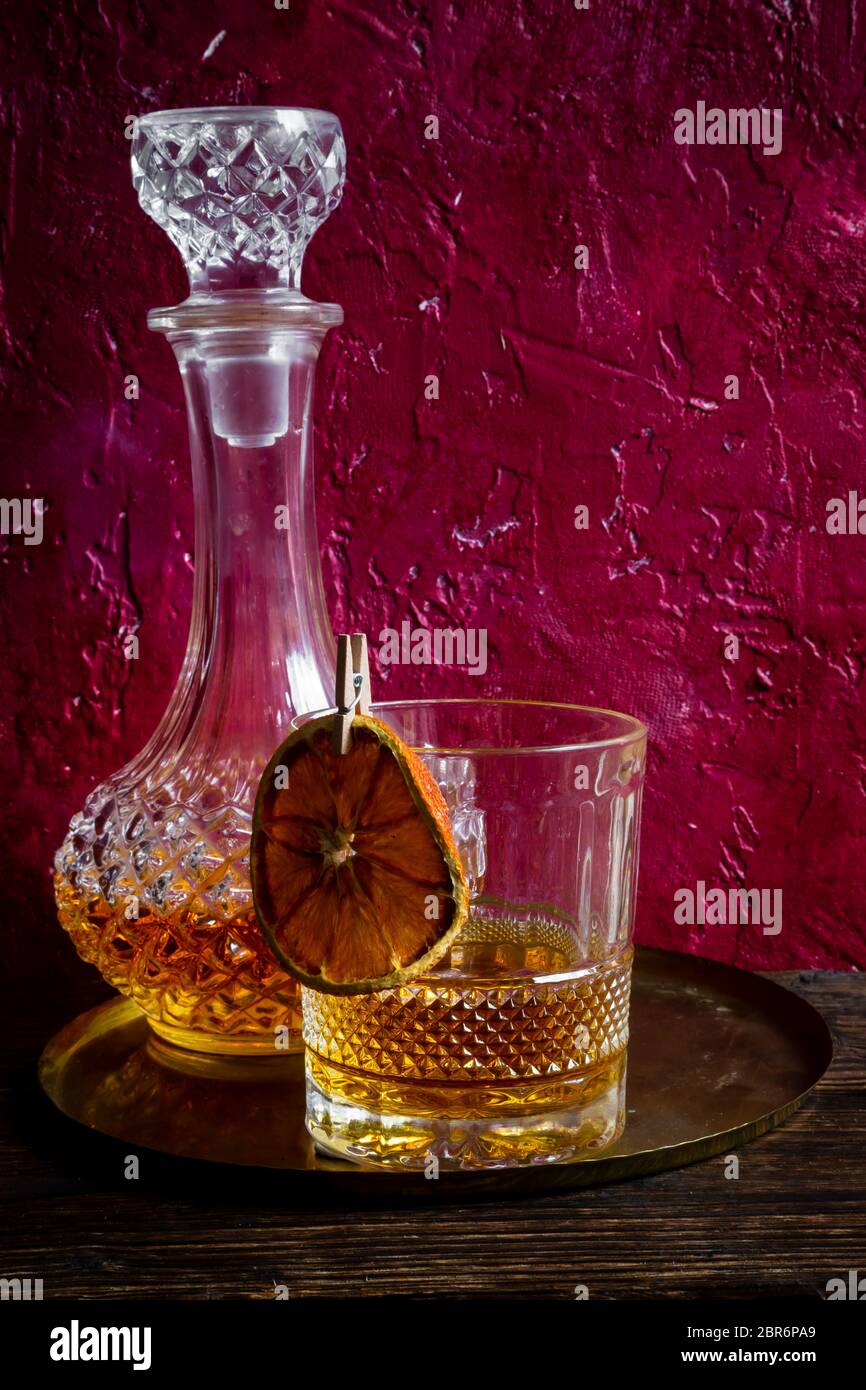 Glass of whiskey on wooden adn red background. Stock Photo