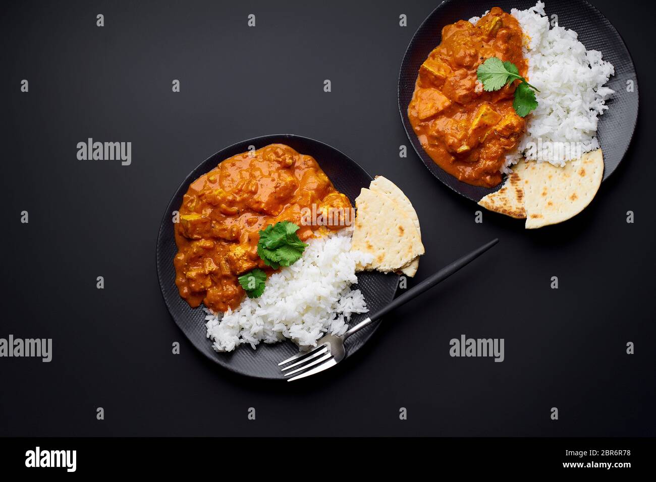 Paneer tikka masala with basmati rice. Indian cuisine, vegetarian dish made of soft cheese cubes cooked in spicy tomato sauce with cream. Top view. Stock Photo