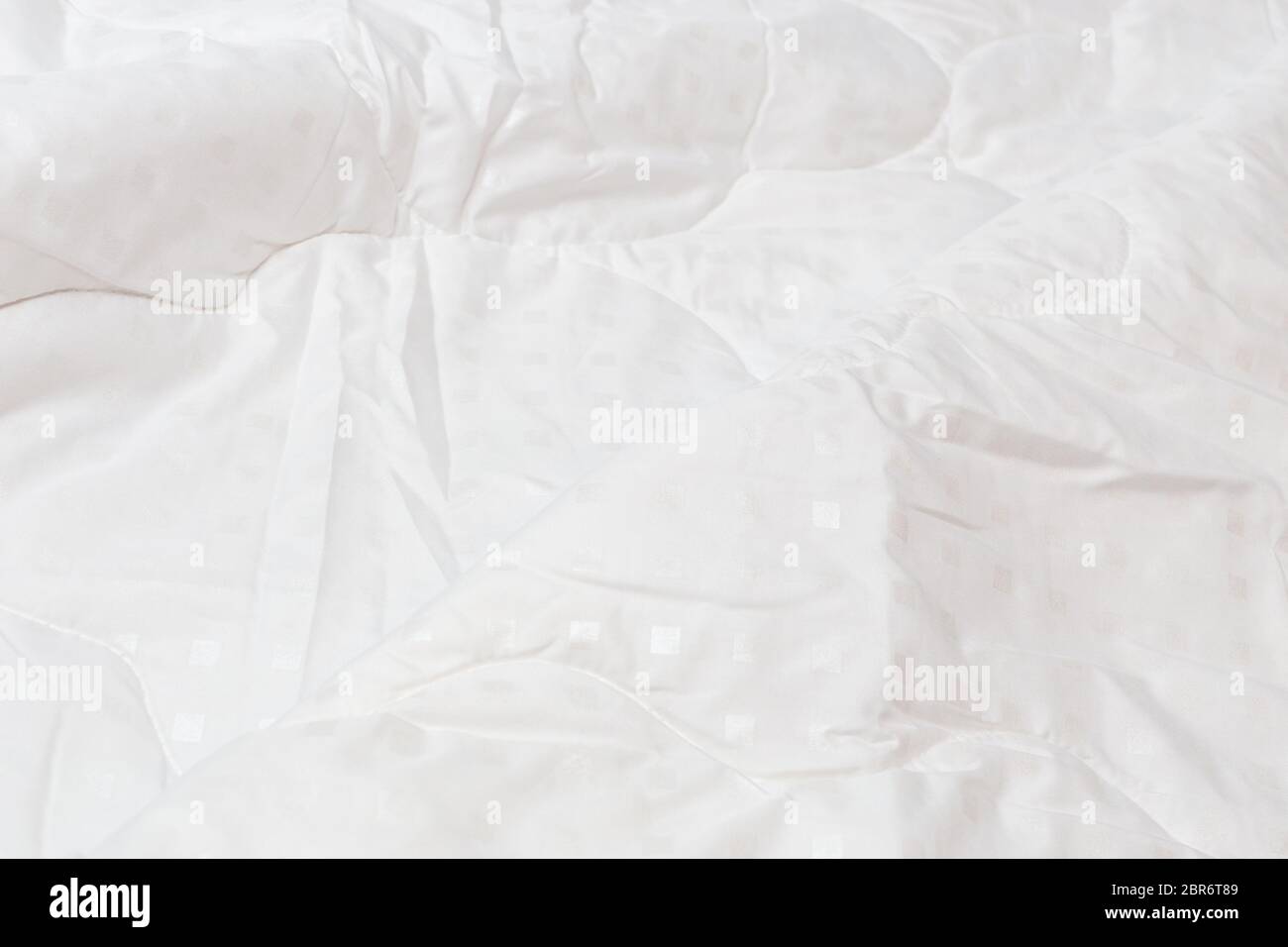 White fabric blanket with one big fold closeup backdrop with selective focus and background