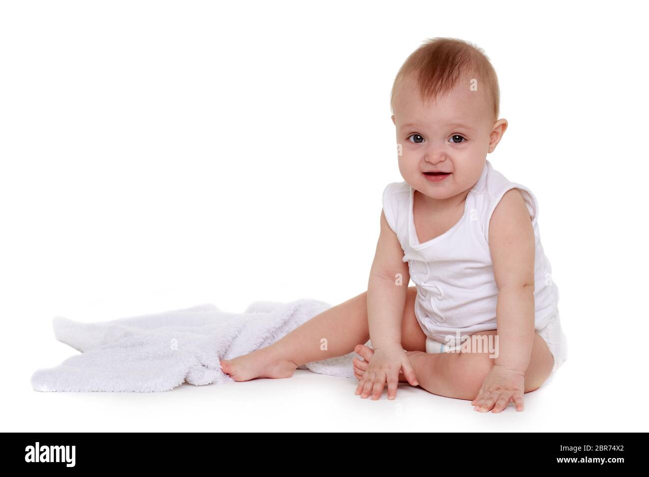 Little baby in diaper is sitting on a plaid on white background. Eight months Stock Photo