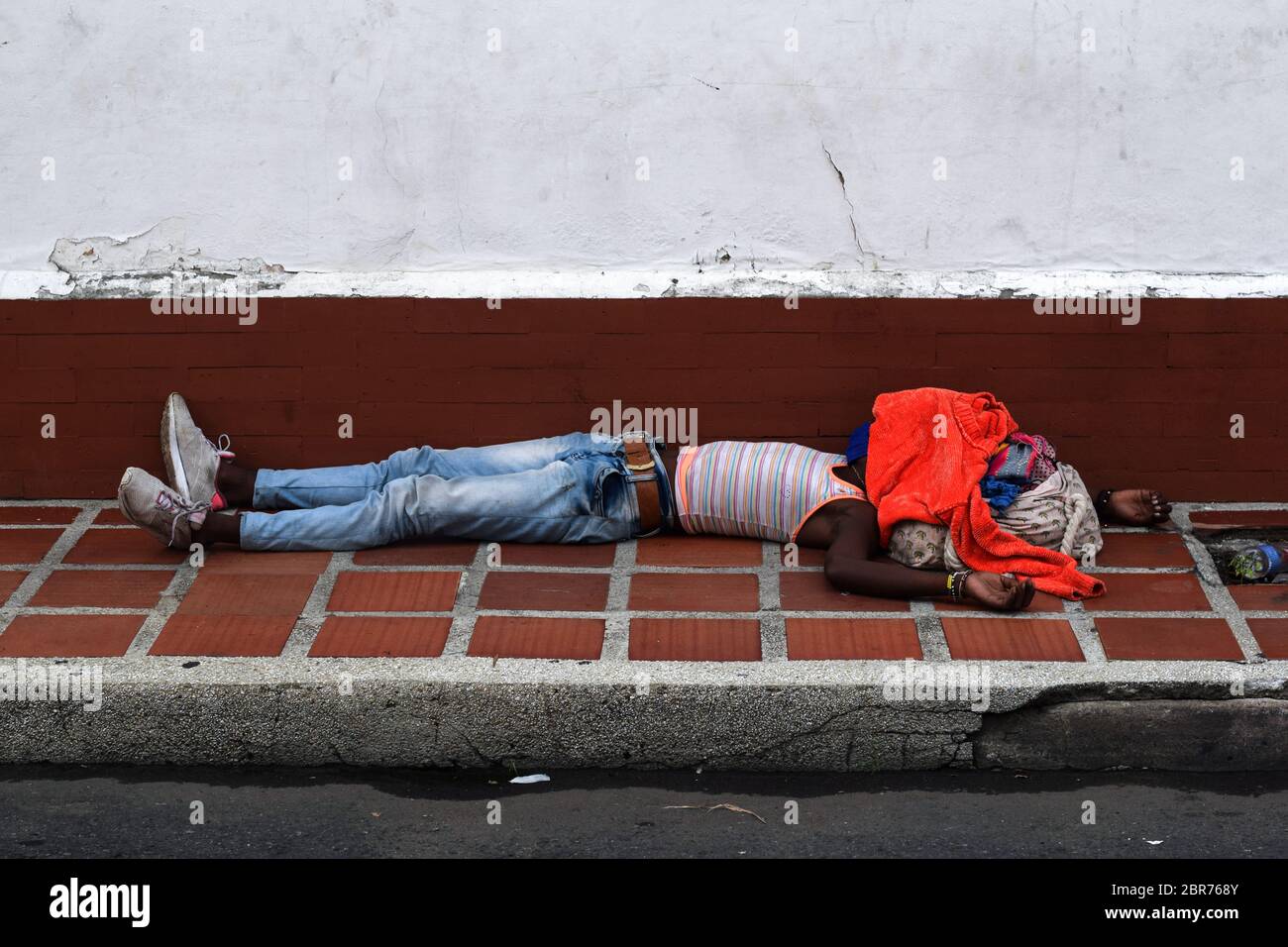 Homeless man sleeping in the streets of Cali during Coronavirus outbreak in Colombia Stock Photo