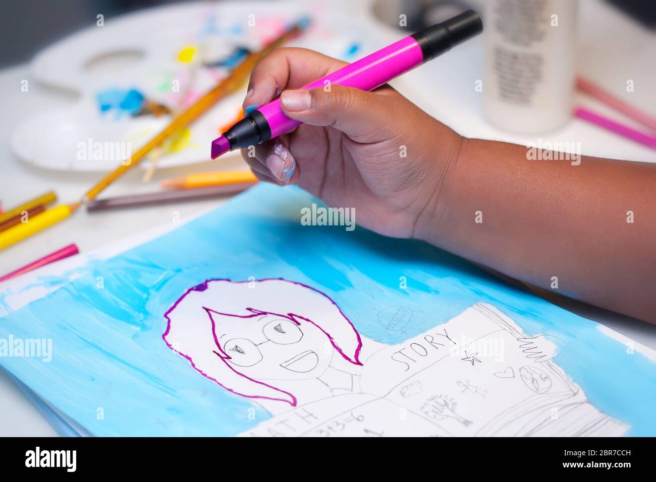 A little kids hand holding a pink art marker and coloring inside the lines of a hand drawn illustration using mixed media. Stock Photo