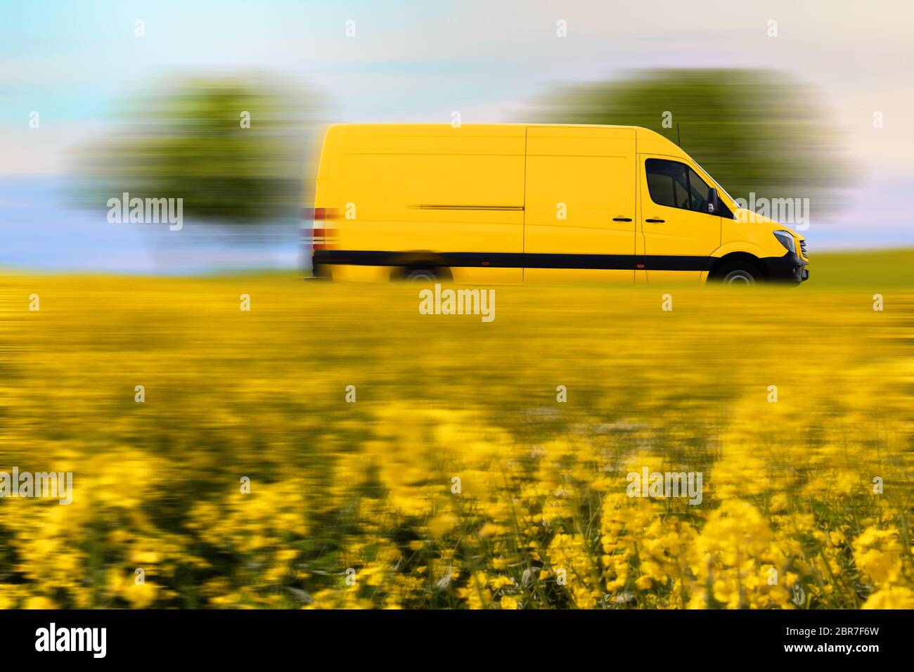 Fast parcel delivery, yellow mail van on country road. Schnelle Paketzustellung, gelber Postwagen auf einer Landstraße. Stock Photo
