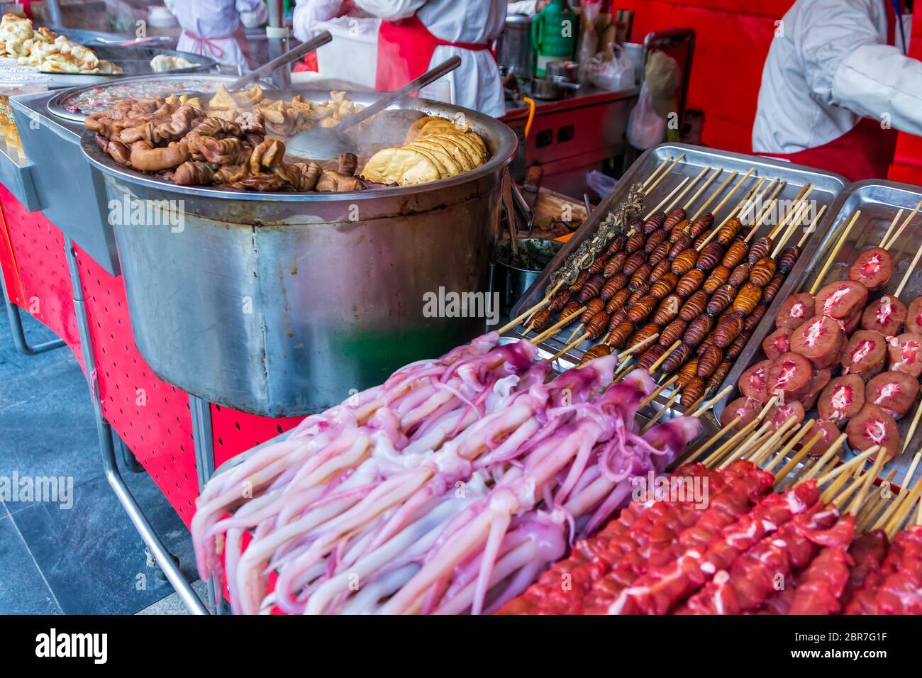Roasted, fried and raw insects, silkworms, scorpions, bugs, snakes, dog meat, octopus on stick as snack street food in China Stock Photo