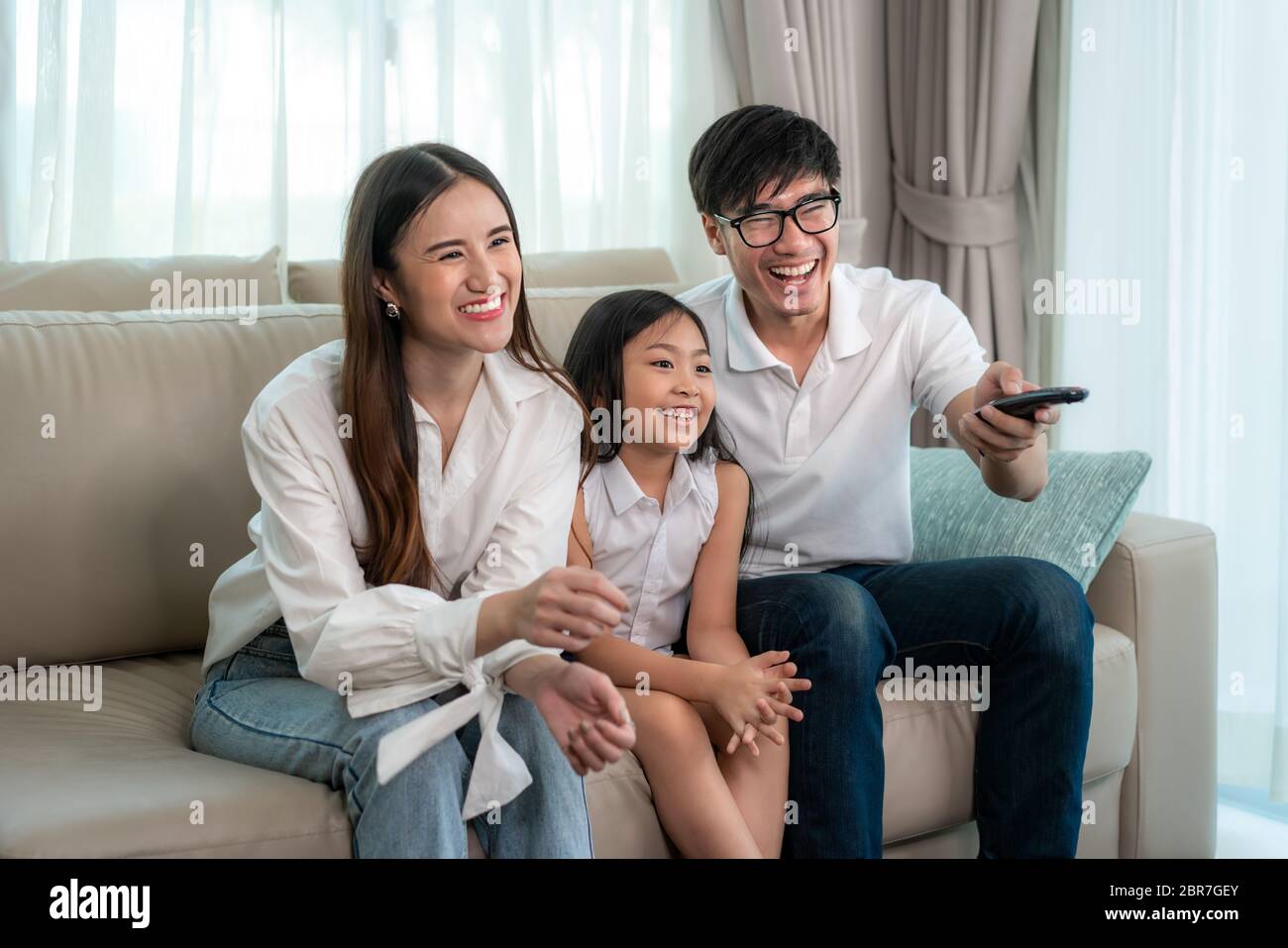 Candid of happy Asian family with father, mother and daughter enjoy weekend activity spending more time at home and therefore probably more time in fr Stock Photo