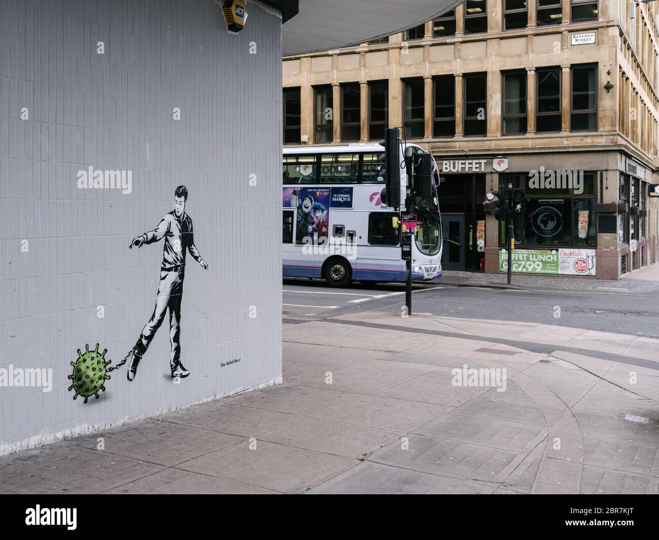 A new mural by street artist 'The Rebel Bear' showing a man chained to a virus molecule, in empty streets in Glasgow city centre, highlighting social distancing guidelines and 'stay at home' advisories should be adhered to during the Coronavirus pandemic lockdown. Stock Photo